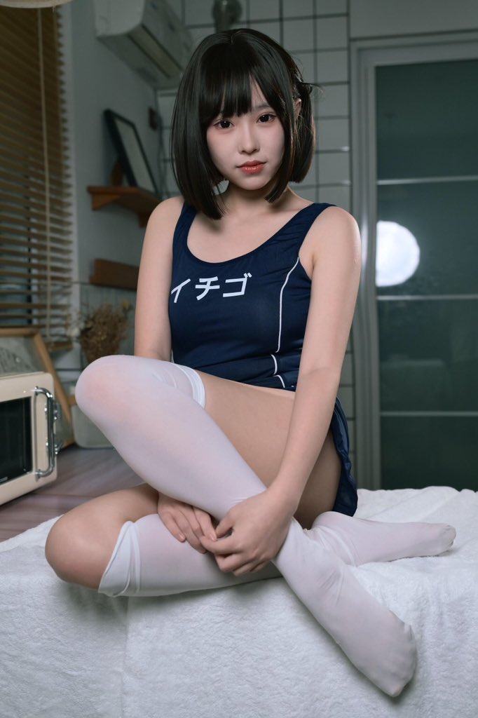 穿着蓝色和白色的泳衣的女人坐在床上。