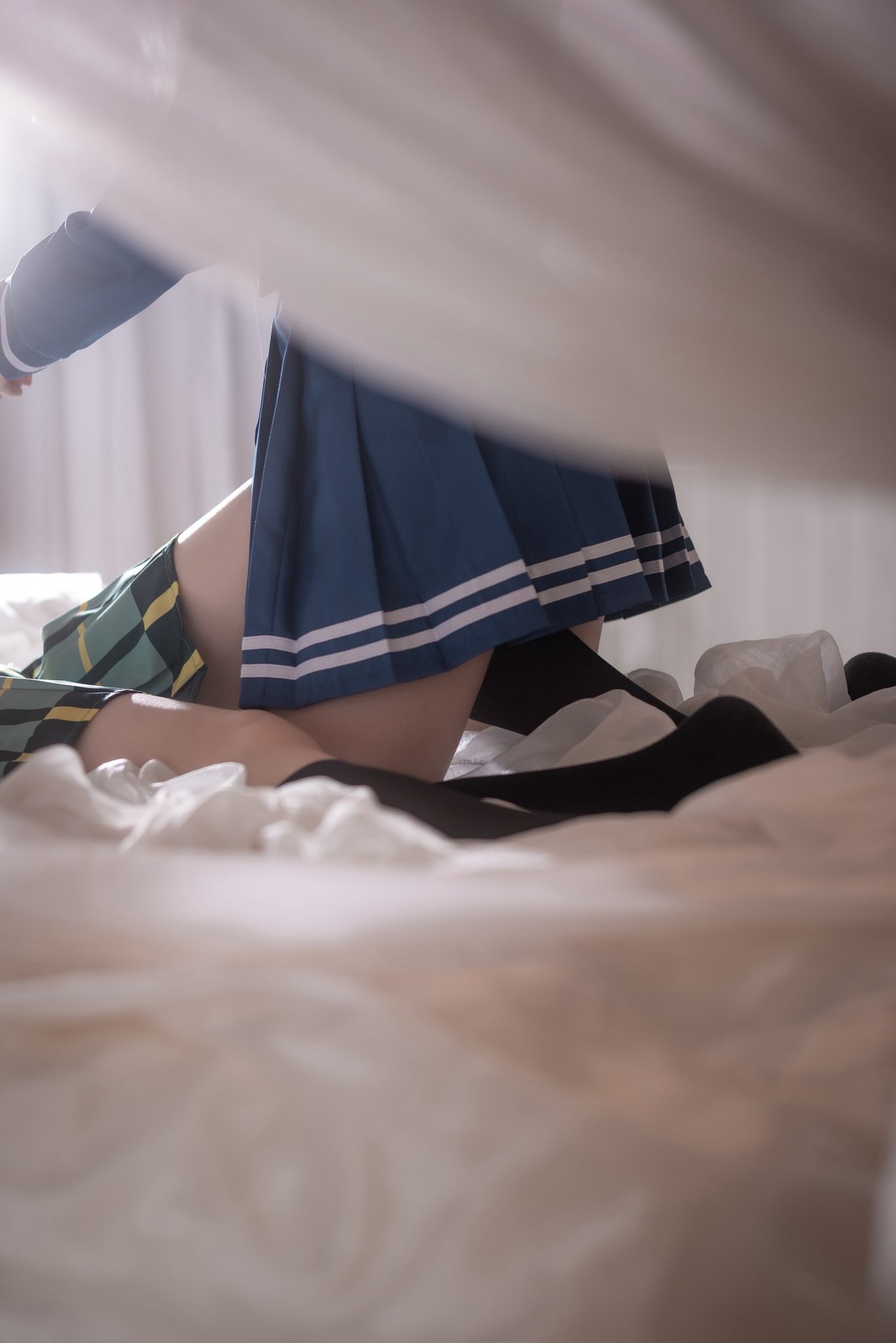 穿着蓝色裙子和袜子的女人坐在床上。