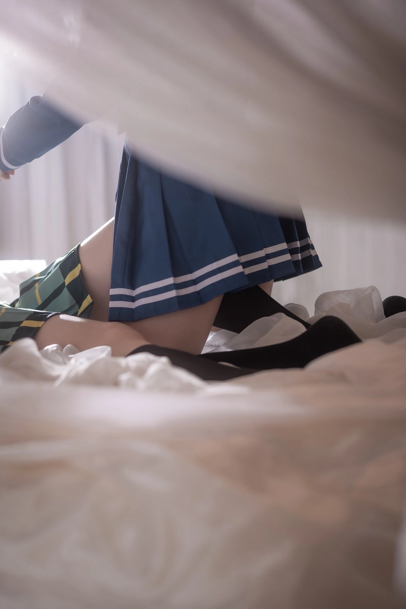 穿着蓝色裙子和袜子的女人坐在床上。