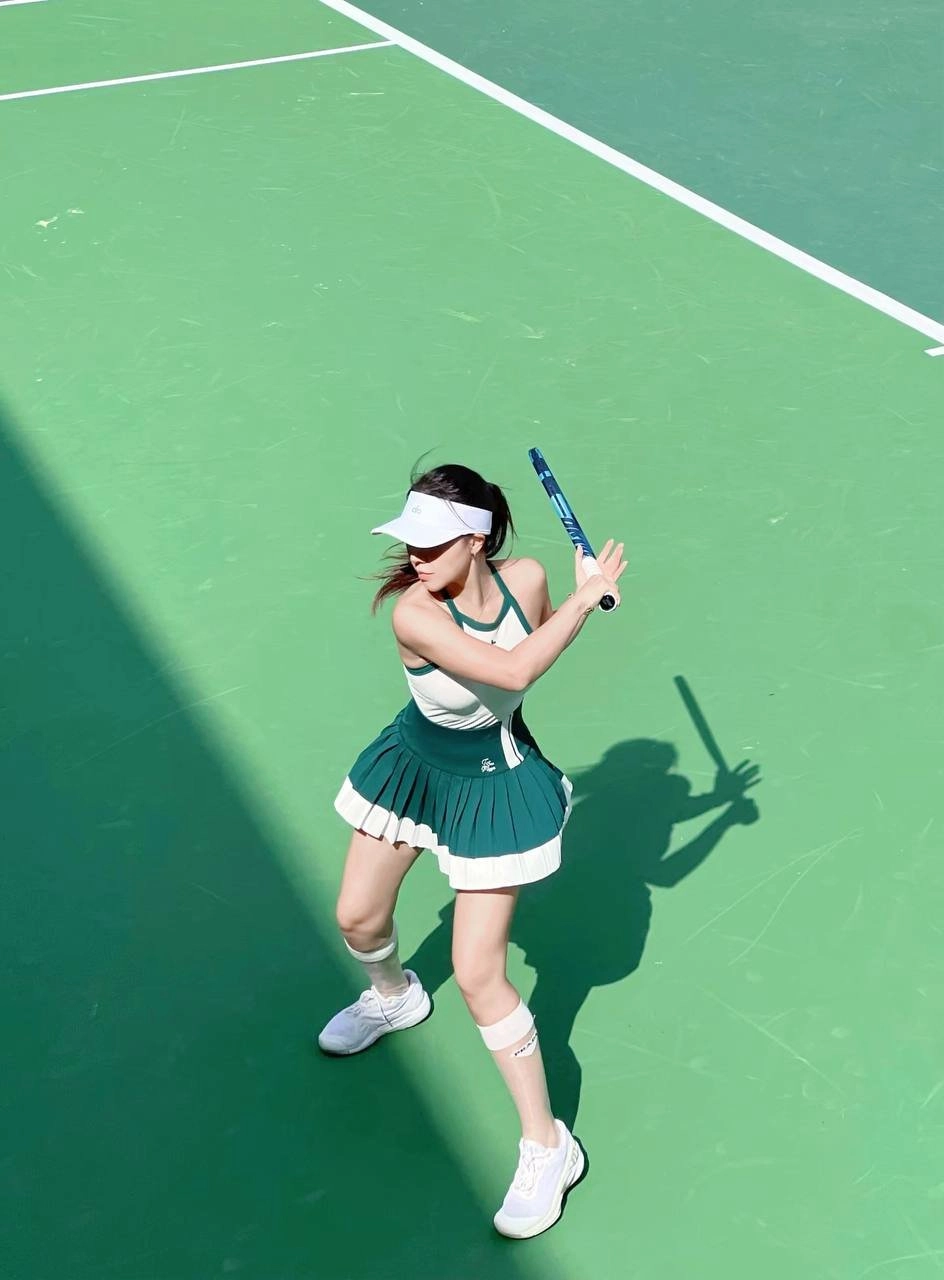Women in green clothes are playing basketball.
