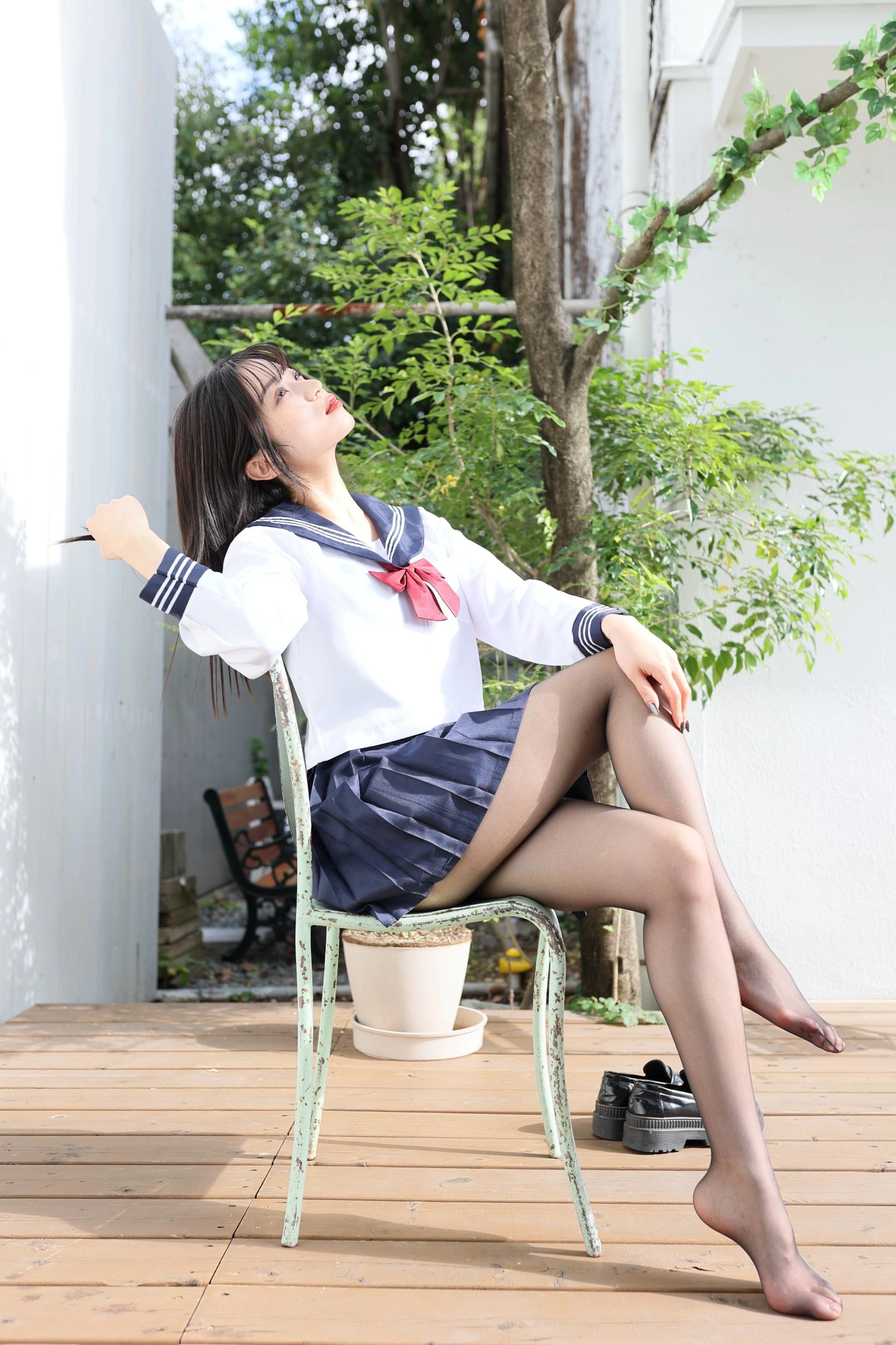 穿着水手服的女人坐在椅子上。