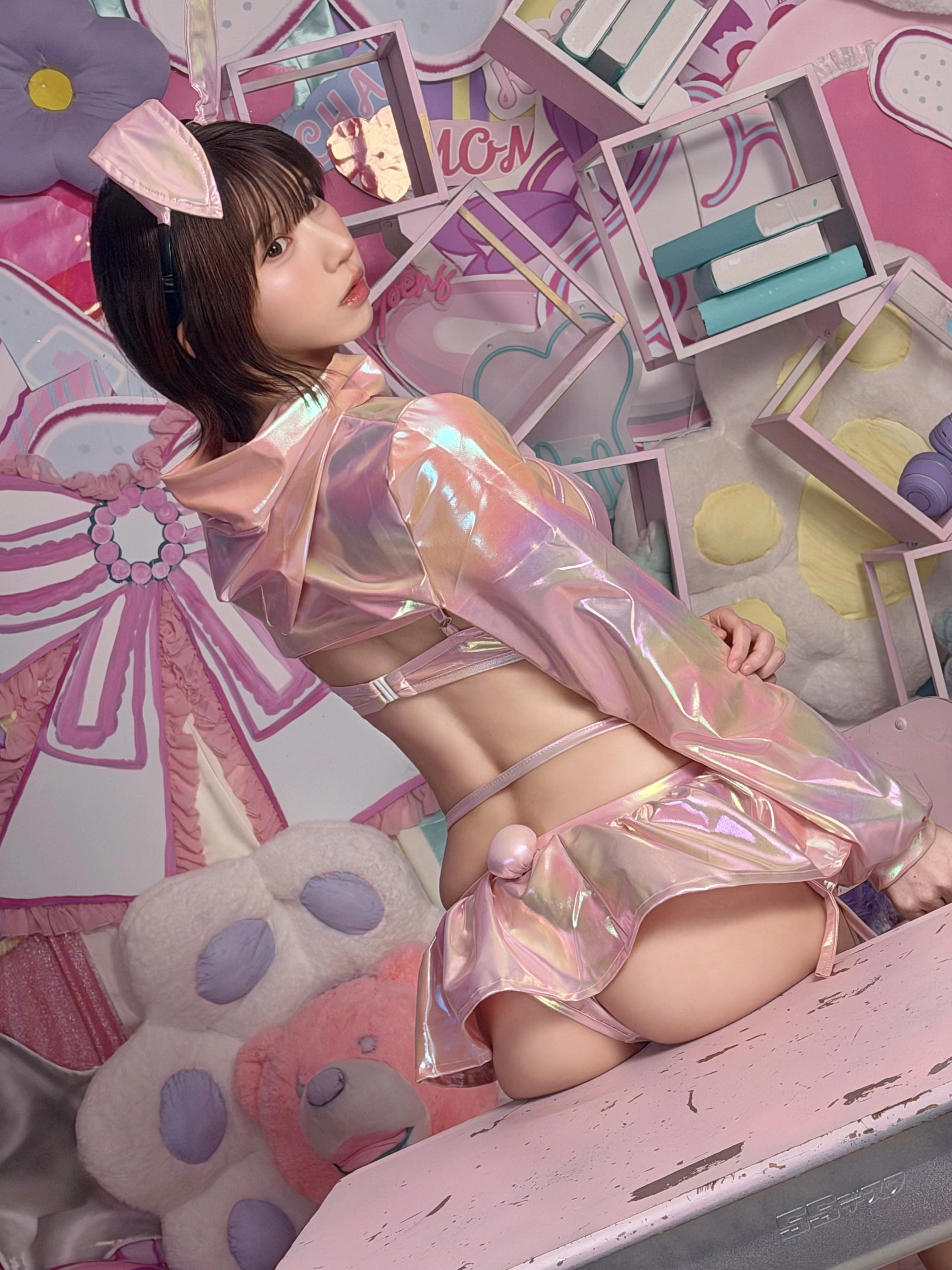 穿着粉红色的裙子和兔耳朵的女人为一张照片。