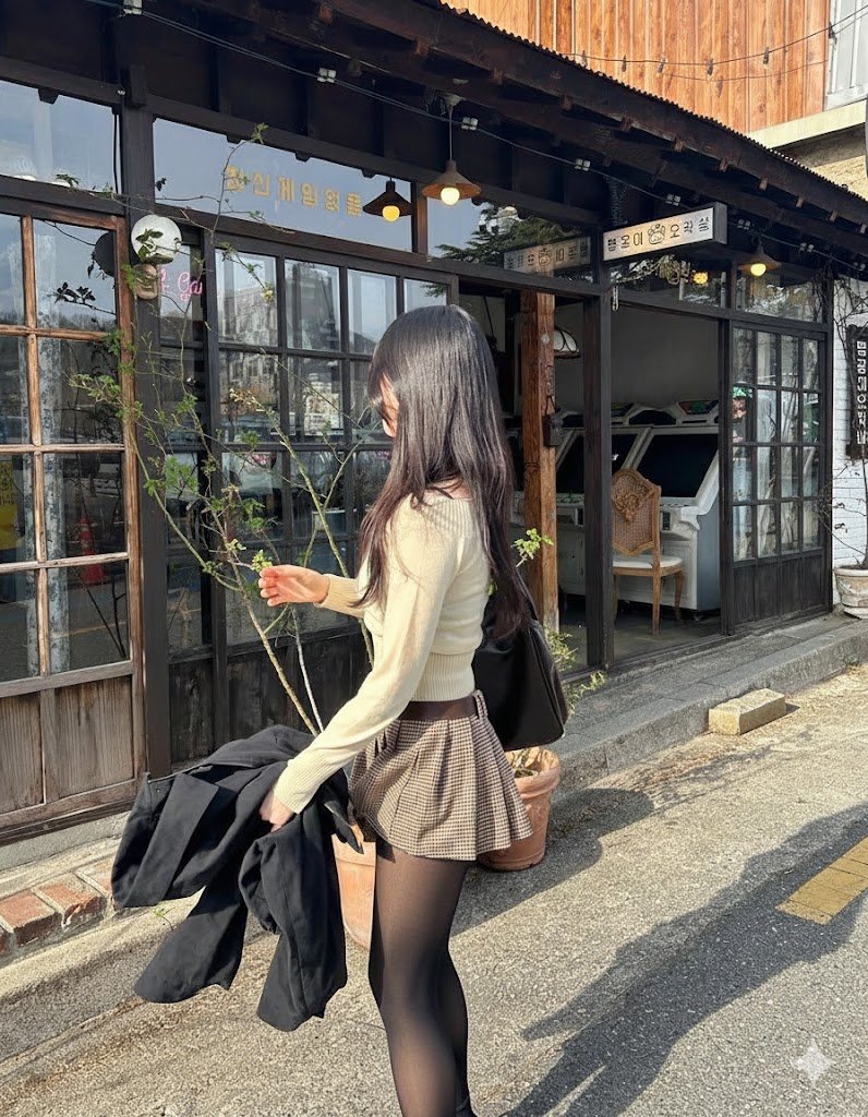 穿着棕色裙子和黑色外套的女人走在街上。