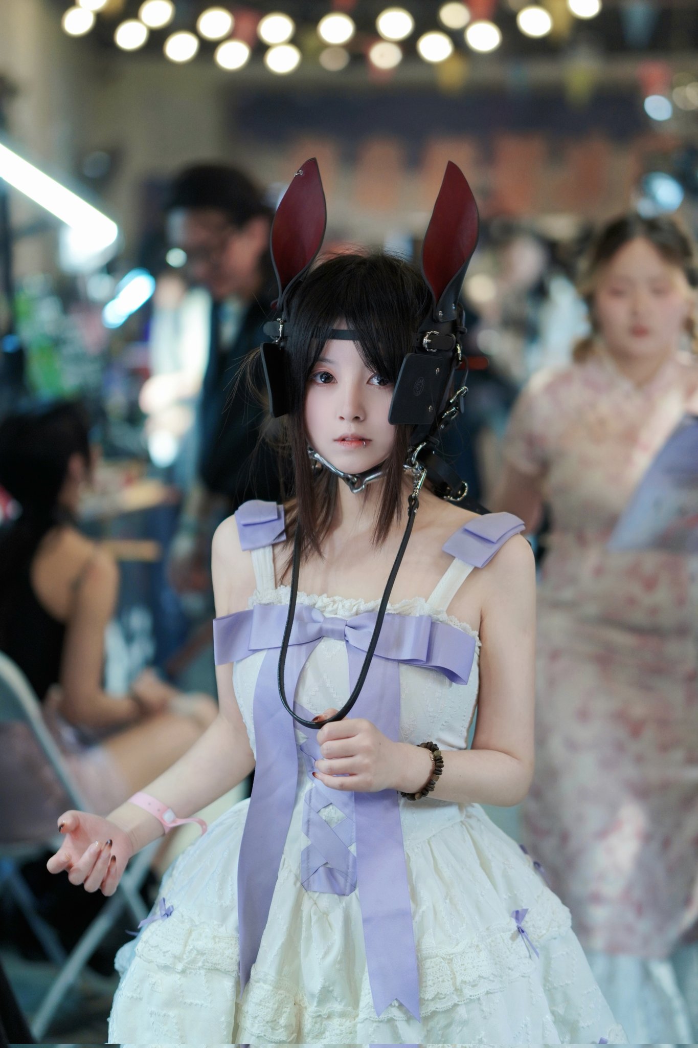 女人穿着一件紫色裙子,头部看起来像兔子的头。