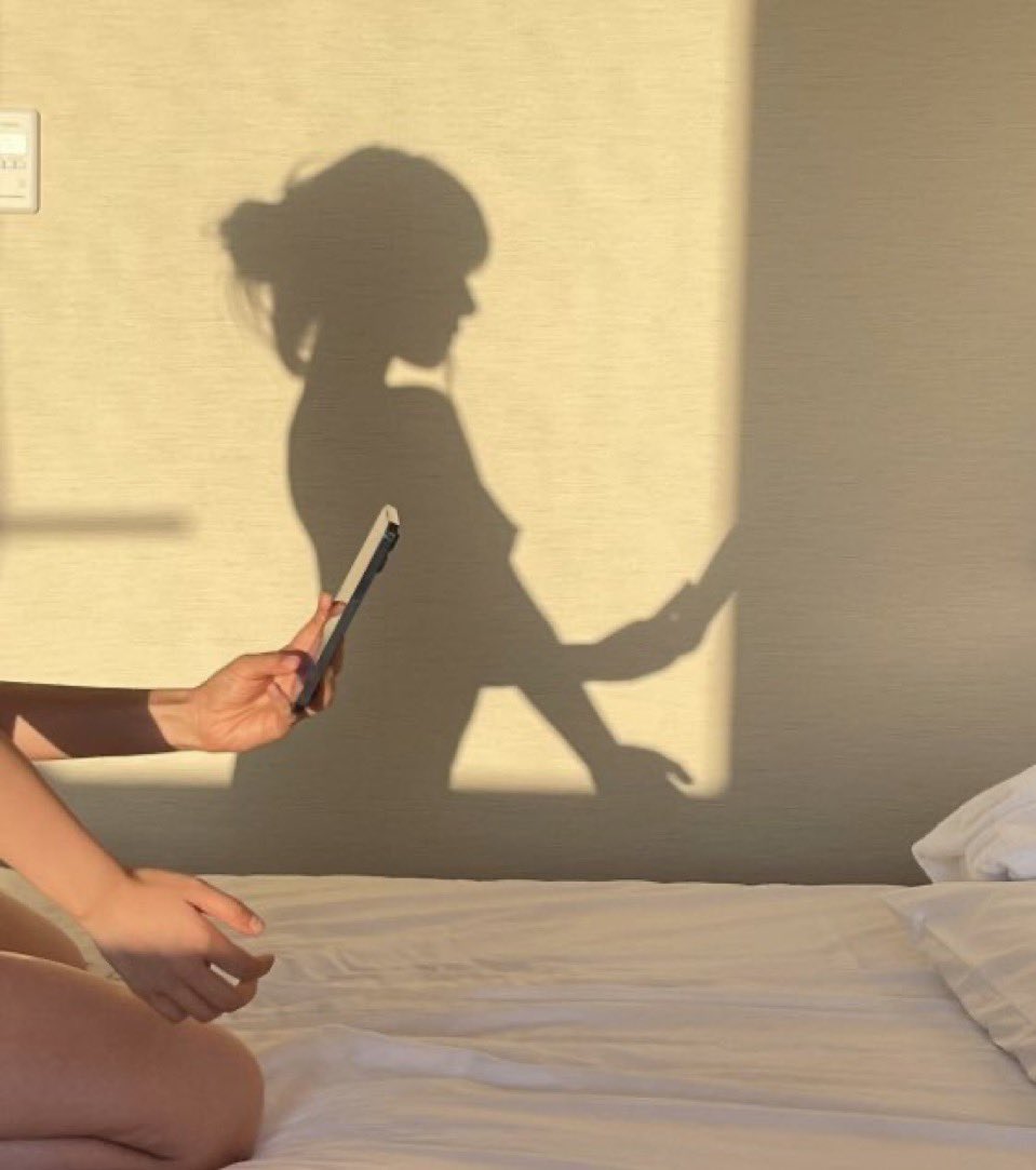 女人坐在床上,看着她的手机。