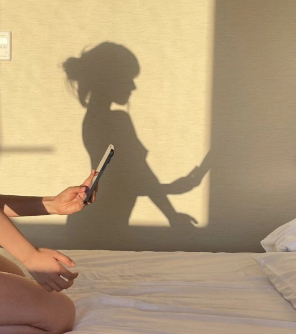 女人坐在床上,看着她的手机。