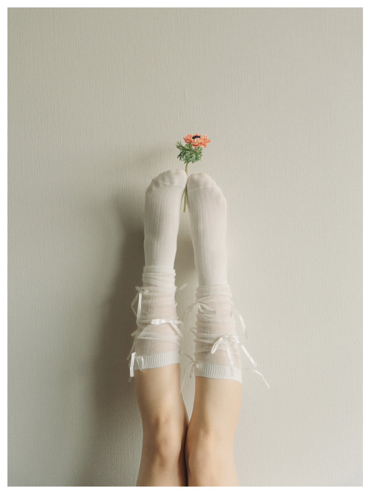 一位穿着白色裤子和粉红色的裙子的女人躺在沙发上。