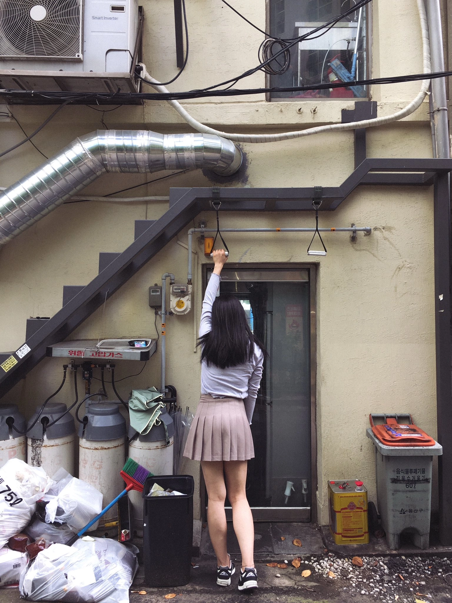 一位穿着裙子的女人挂着一幅画在墙上。