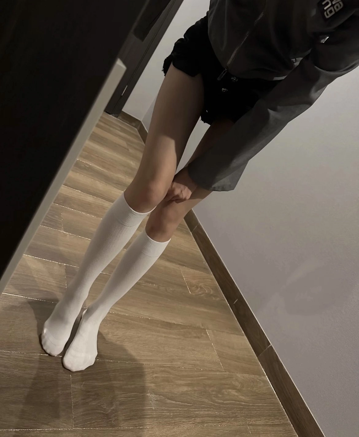 穿着白色袜子和灰色夹克的女人。