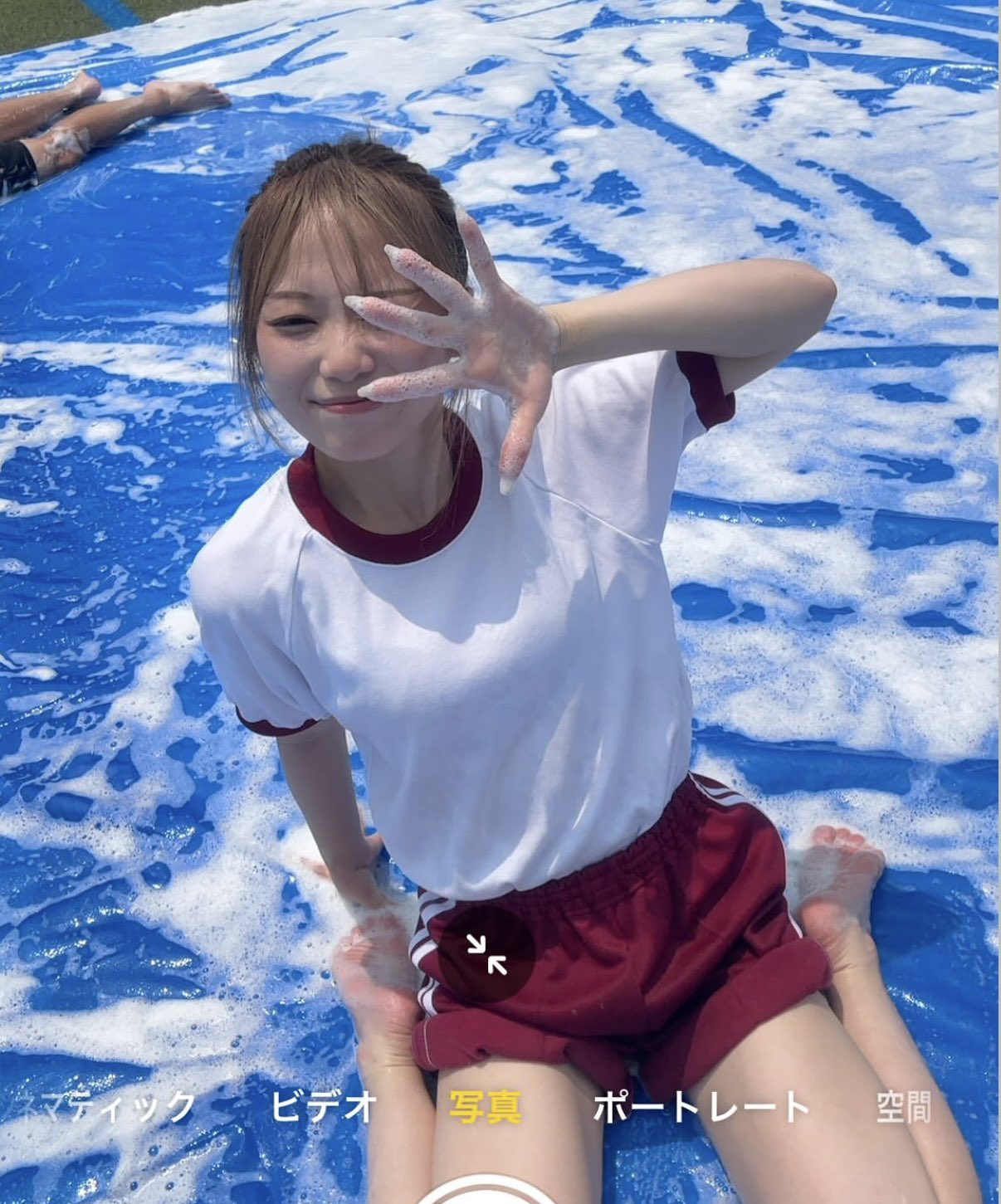 穿着白衬衫和红色短裤的女孩坐在游泳池里。