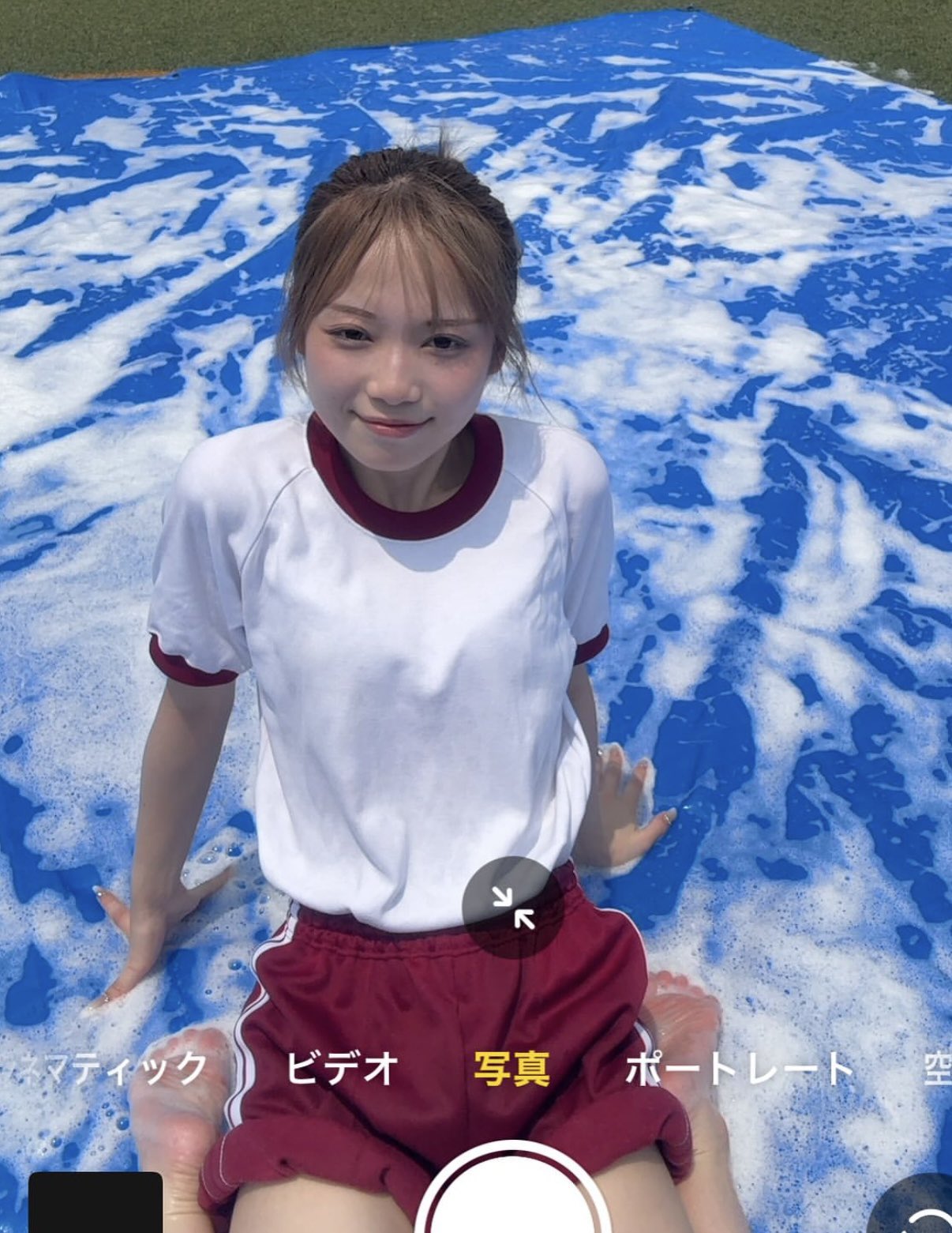 穿着白衬衫和红色短裤的女孩坐在游泳池里。