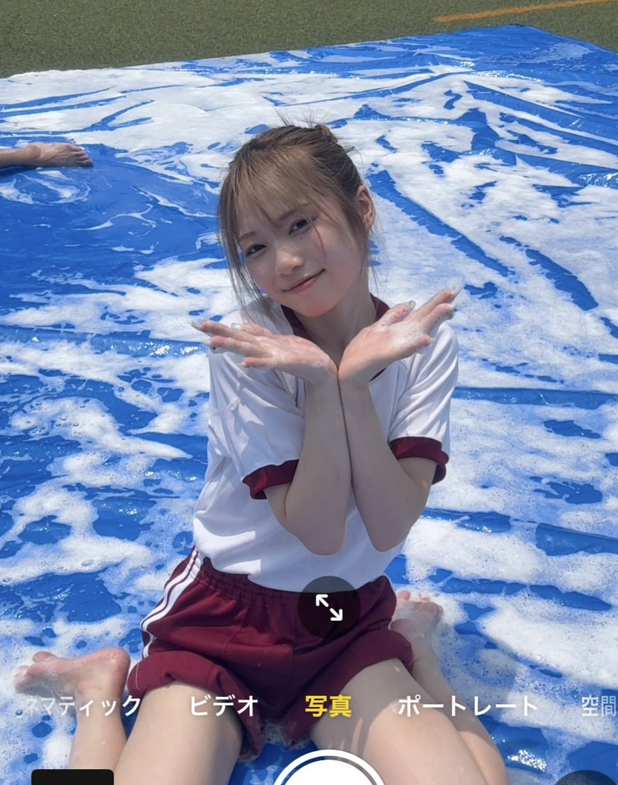 穿着白衬衫和红色短裤的女孩坐在游泳池里。