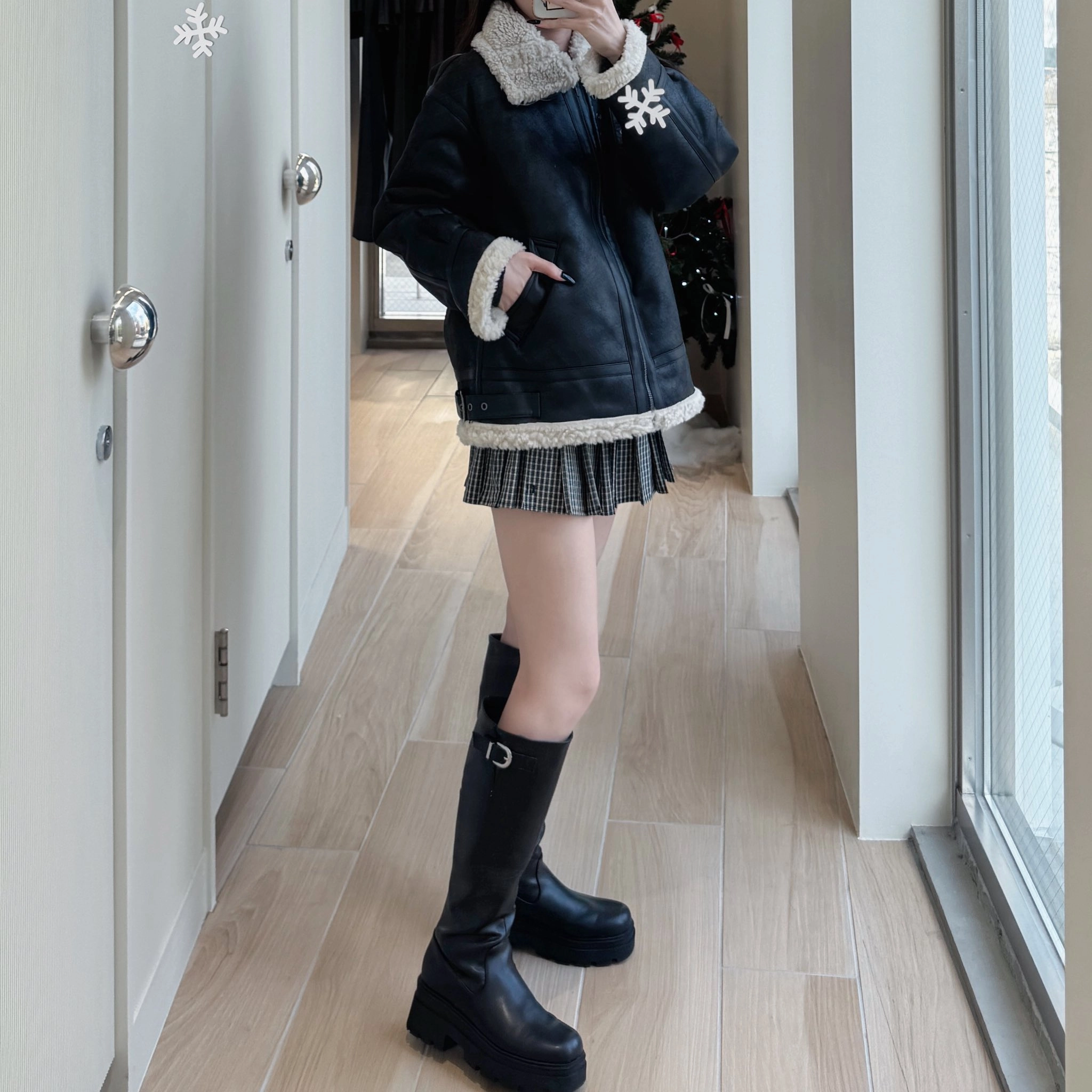 穿着黑色夹克和黑靴子的女人。