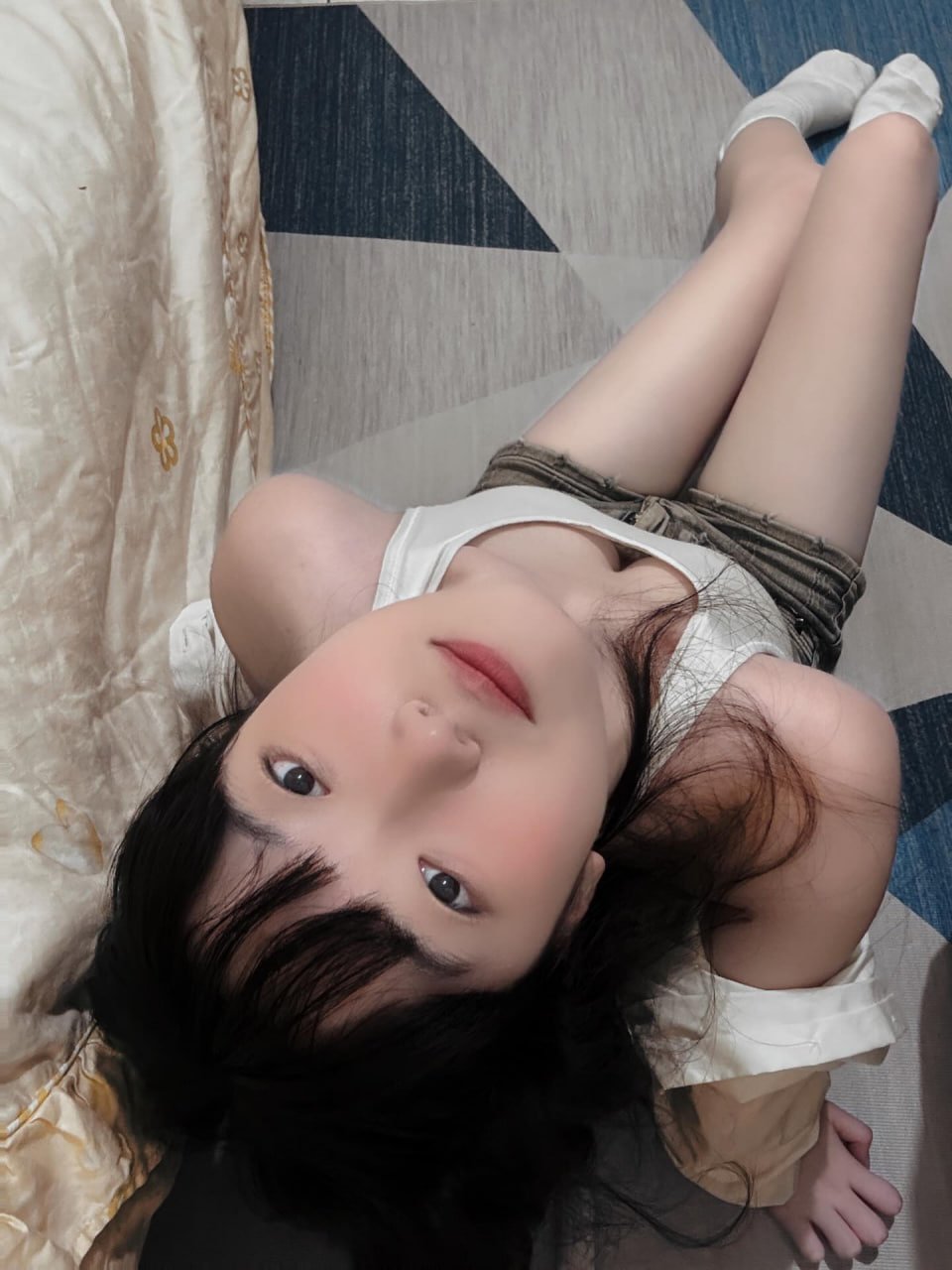 黑头发和白衬衫的女人躺在床上。