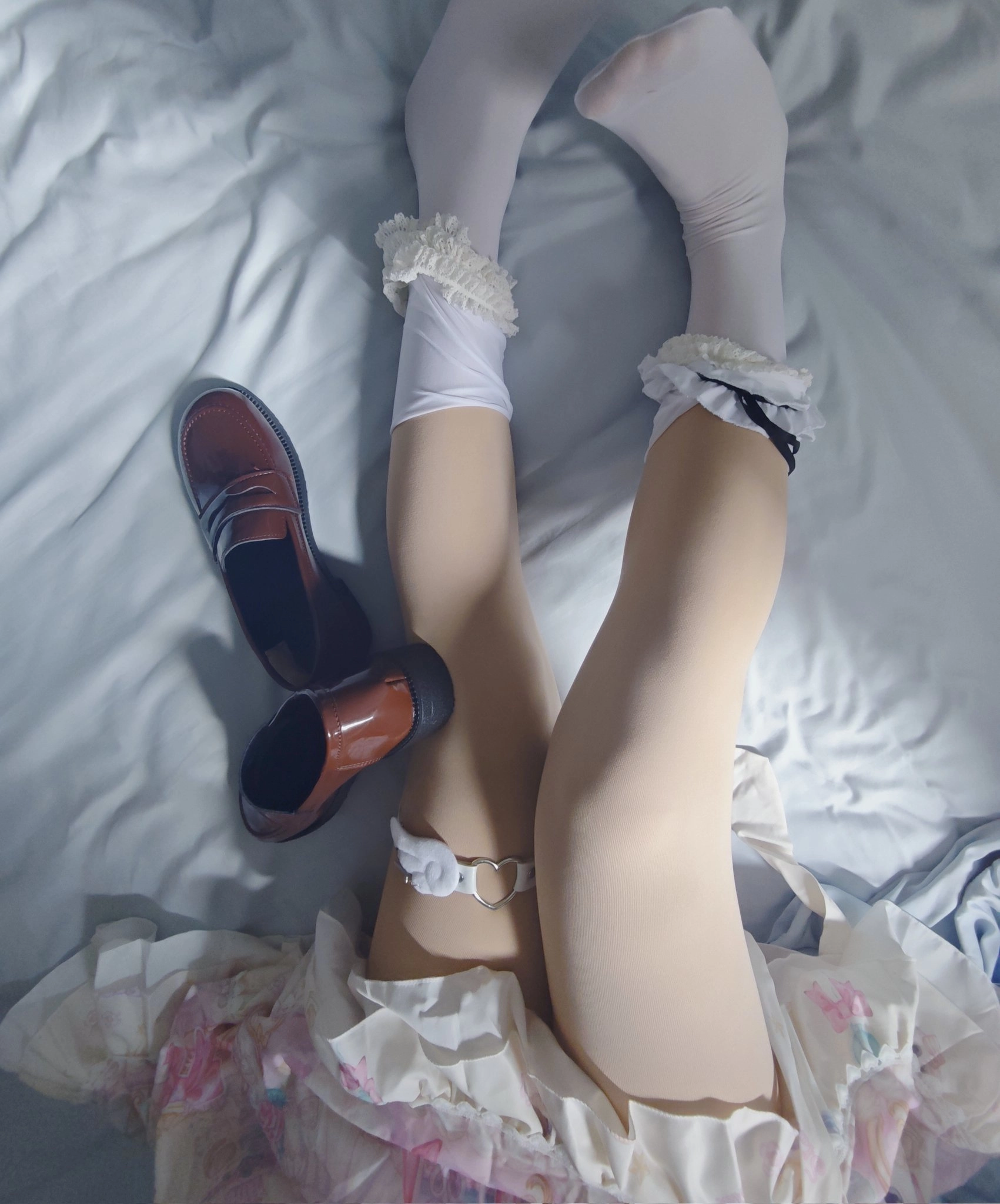 一位穿着裙子和袜子的女人躺在床上,旁边有一双鞋子。