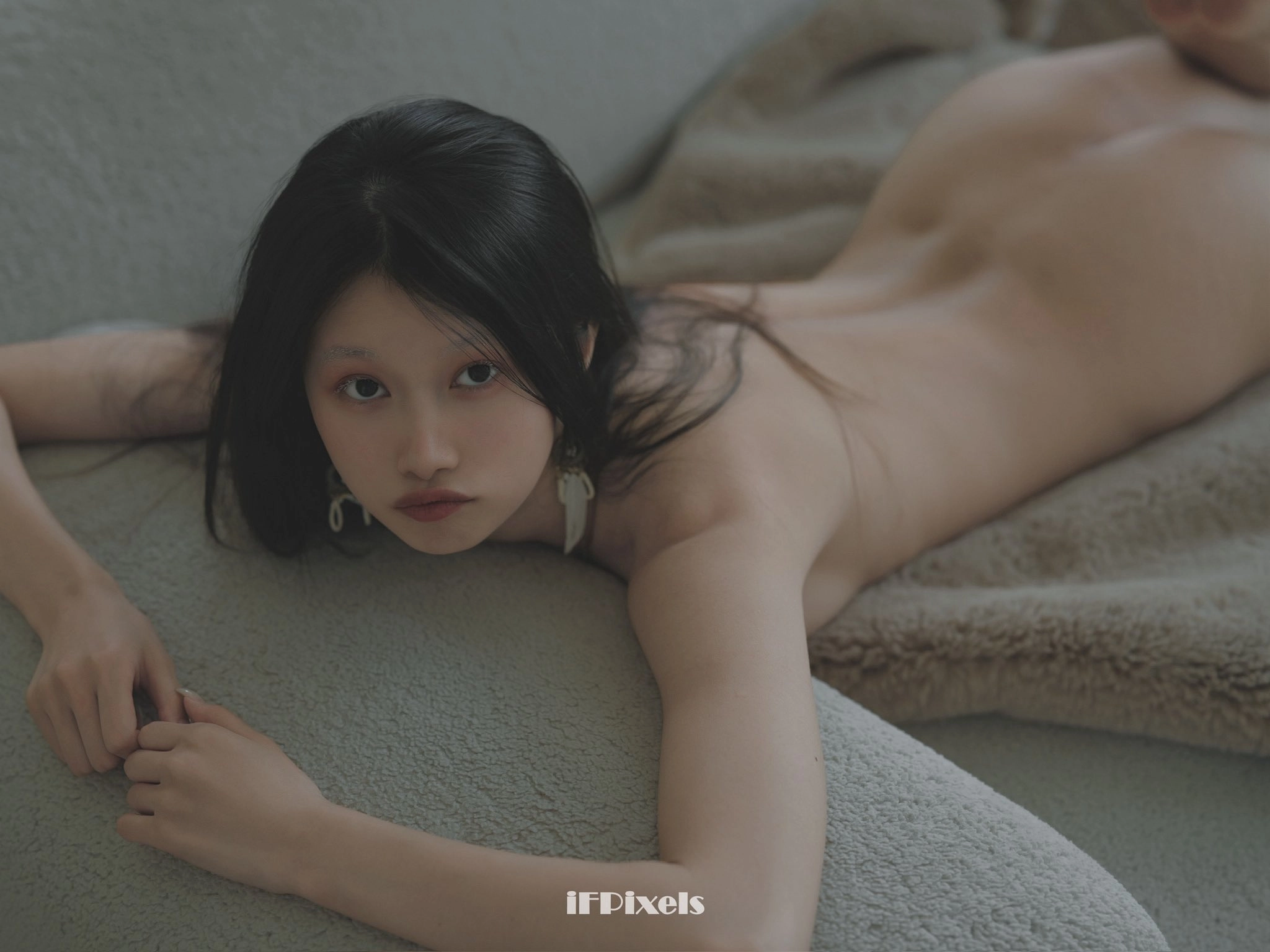 The woman sits on the couch and turns her back.