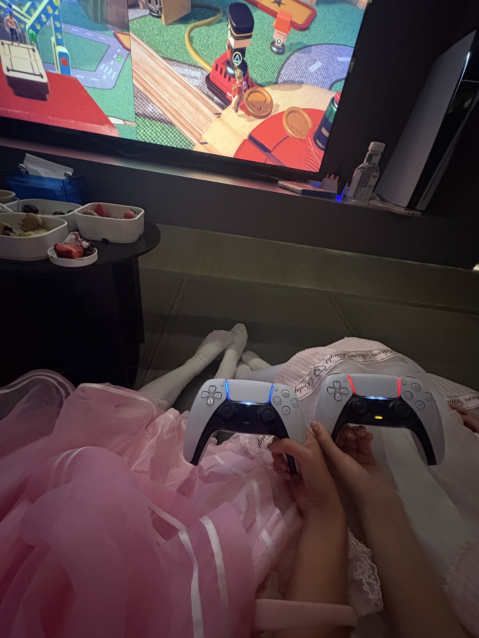 一位穿着粉红色的裙子和白色裤子的年轻女孩坐在沙发上。