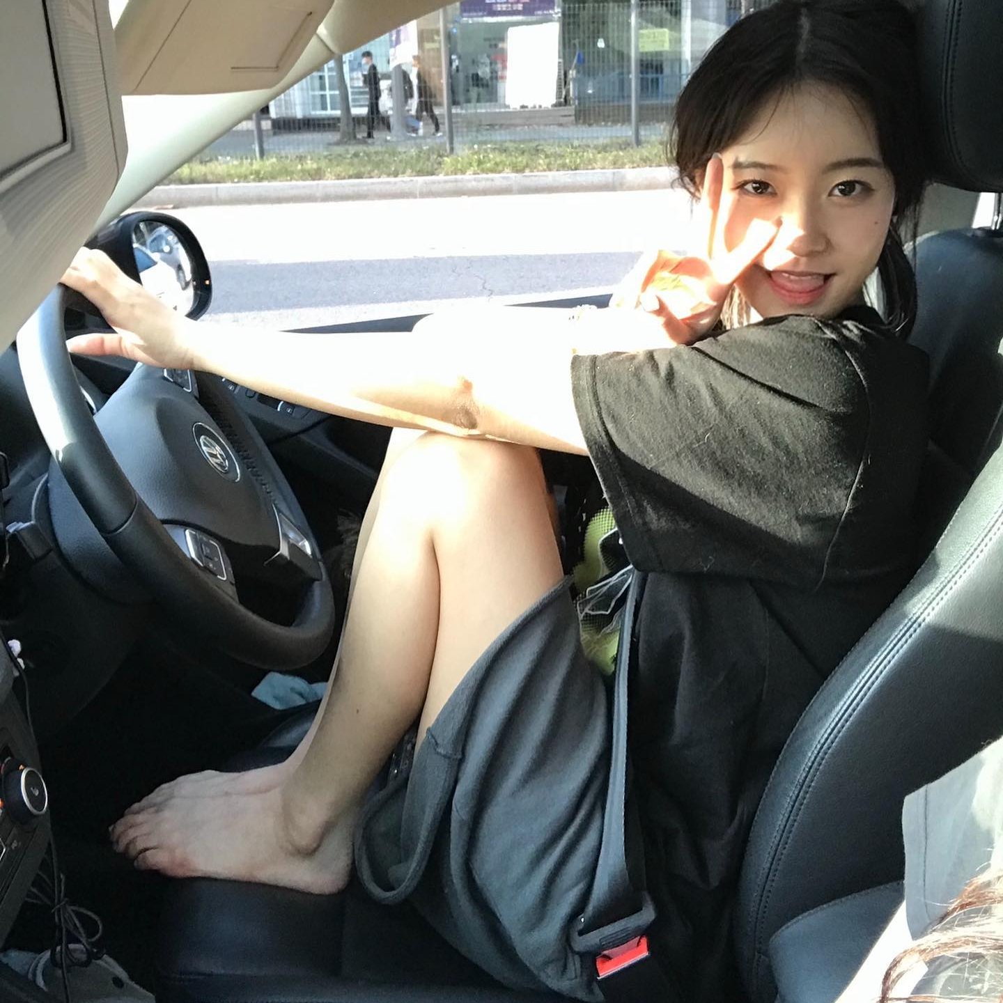 女孩在一辆车里,正在发出和平的信号。