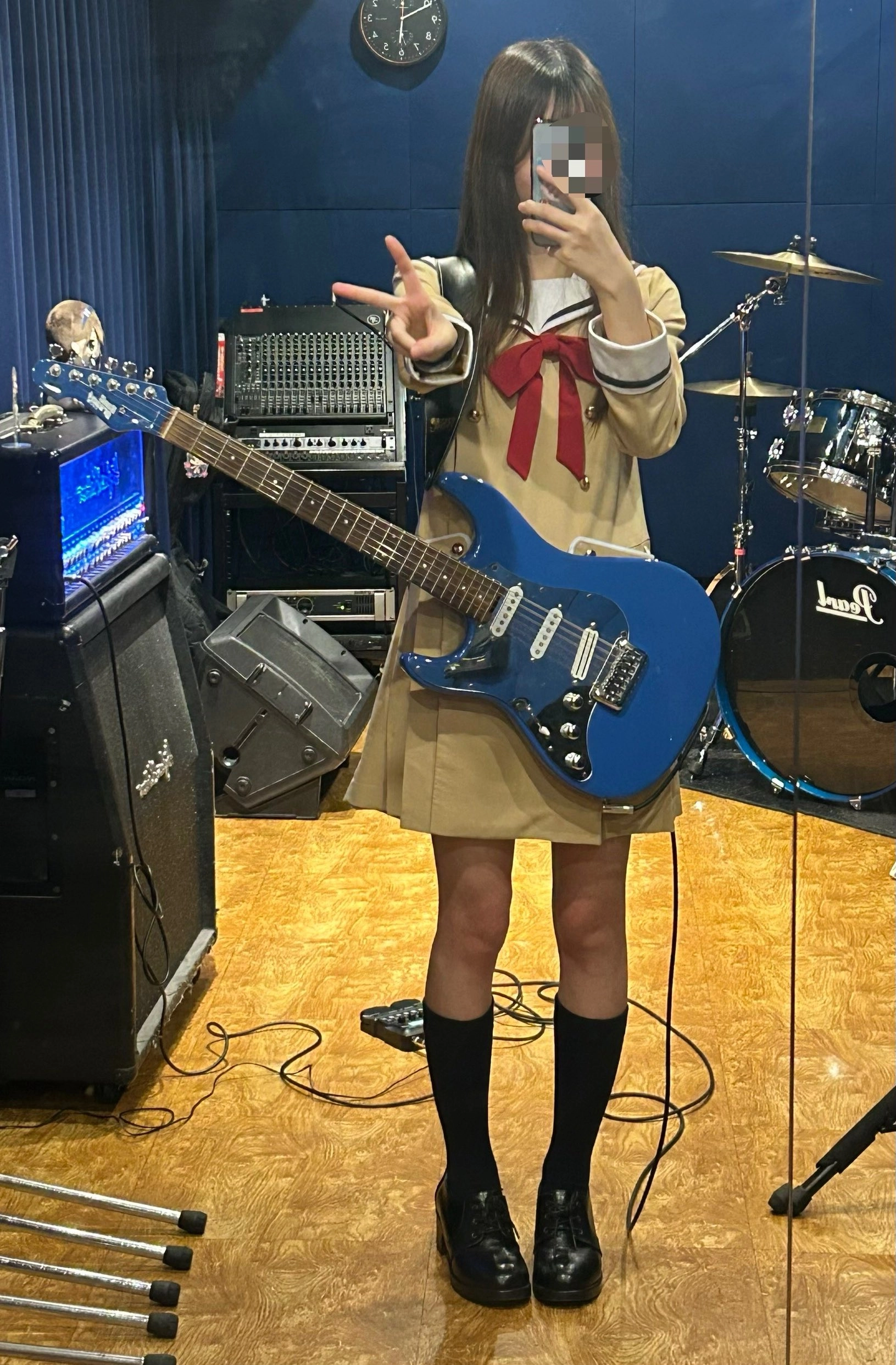 穿着校服的女孩拿着吉他。