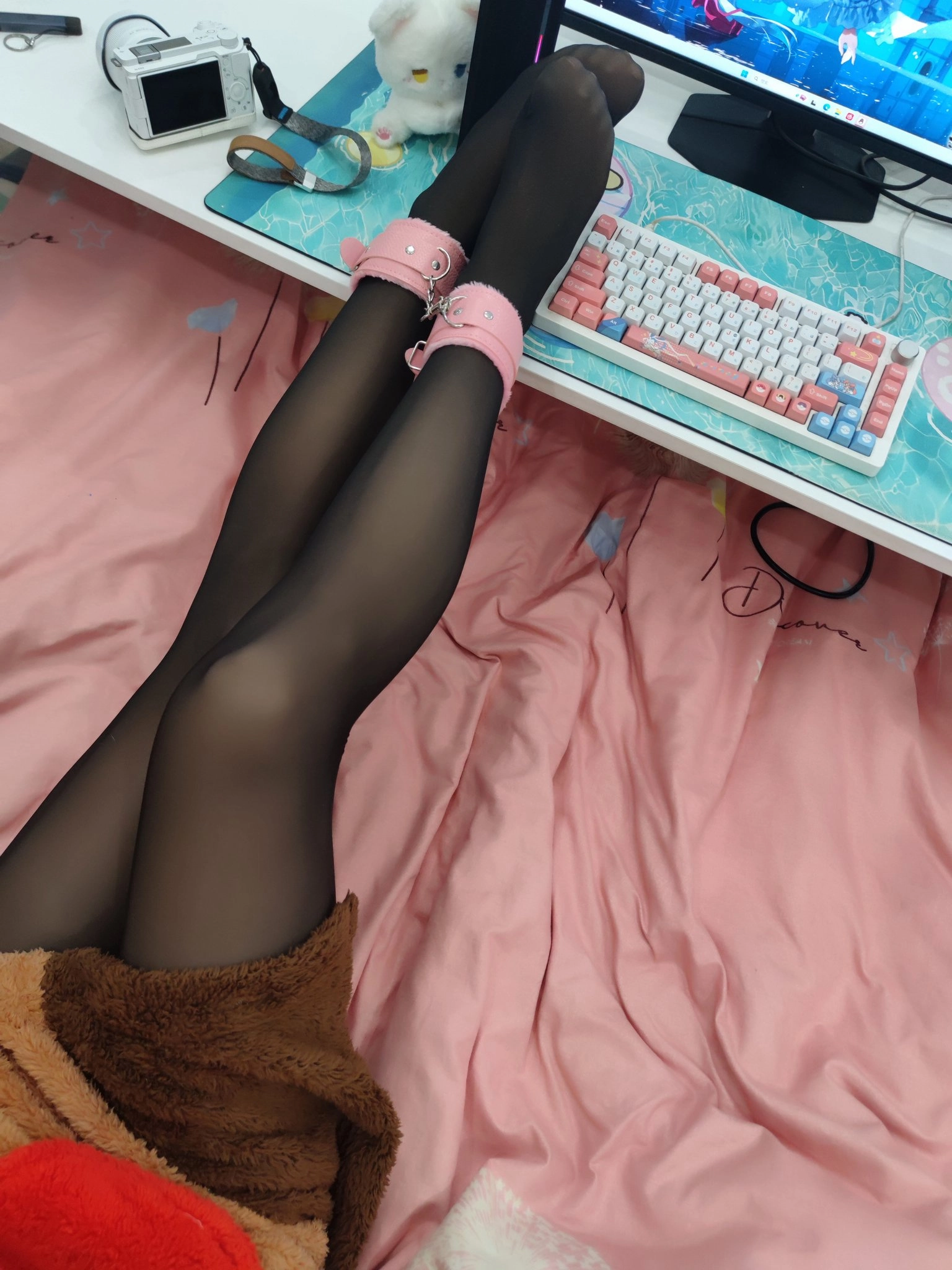 一位穿着黑色袜子和粉红色鞋子的女人躺在一张电脑键盘上的床上。