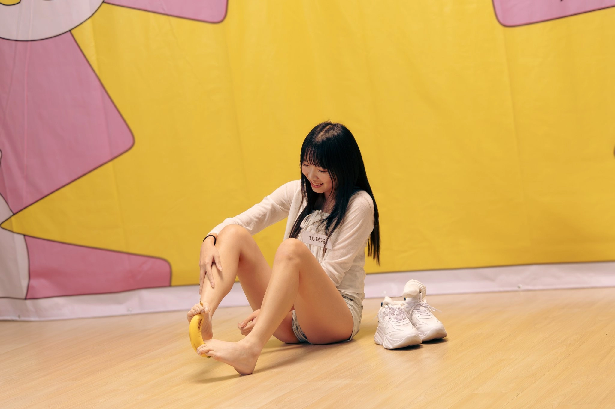 女人坐在地板上,手里拿着香蕉。