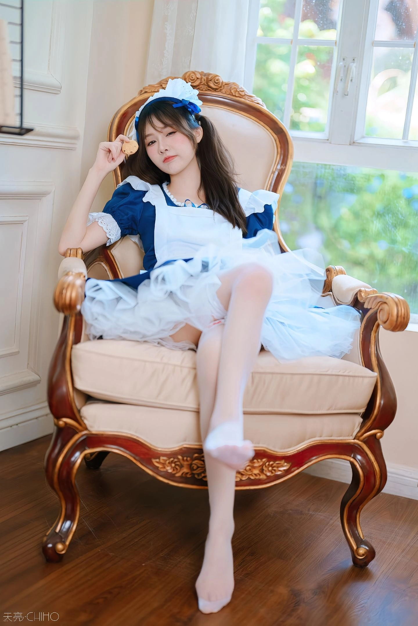 穿着蓝色衣服的女孩坐在椅子上。