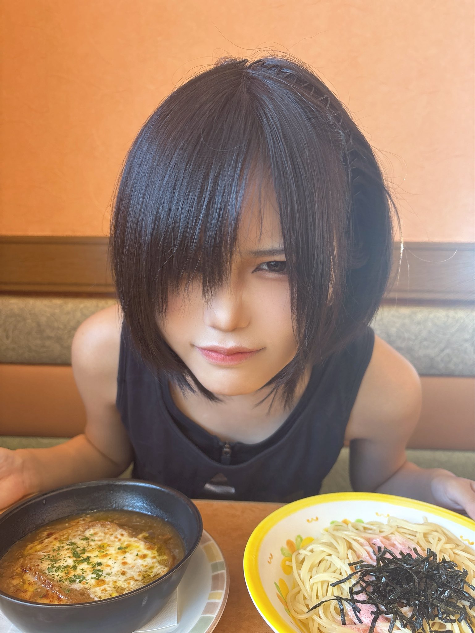 黑头发和黑色坦克顶的女孩正在看着相机。