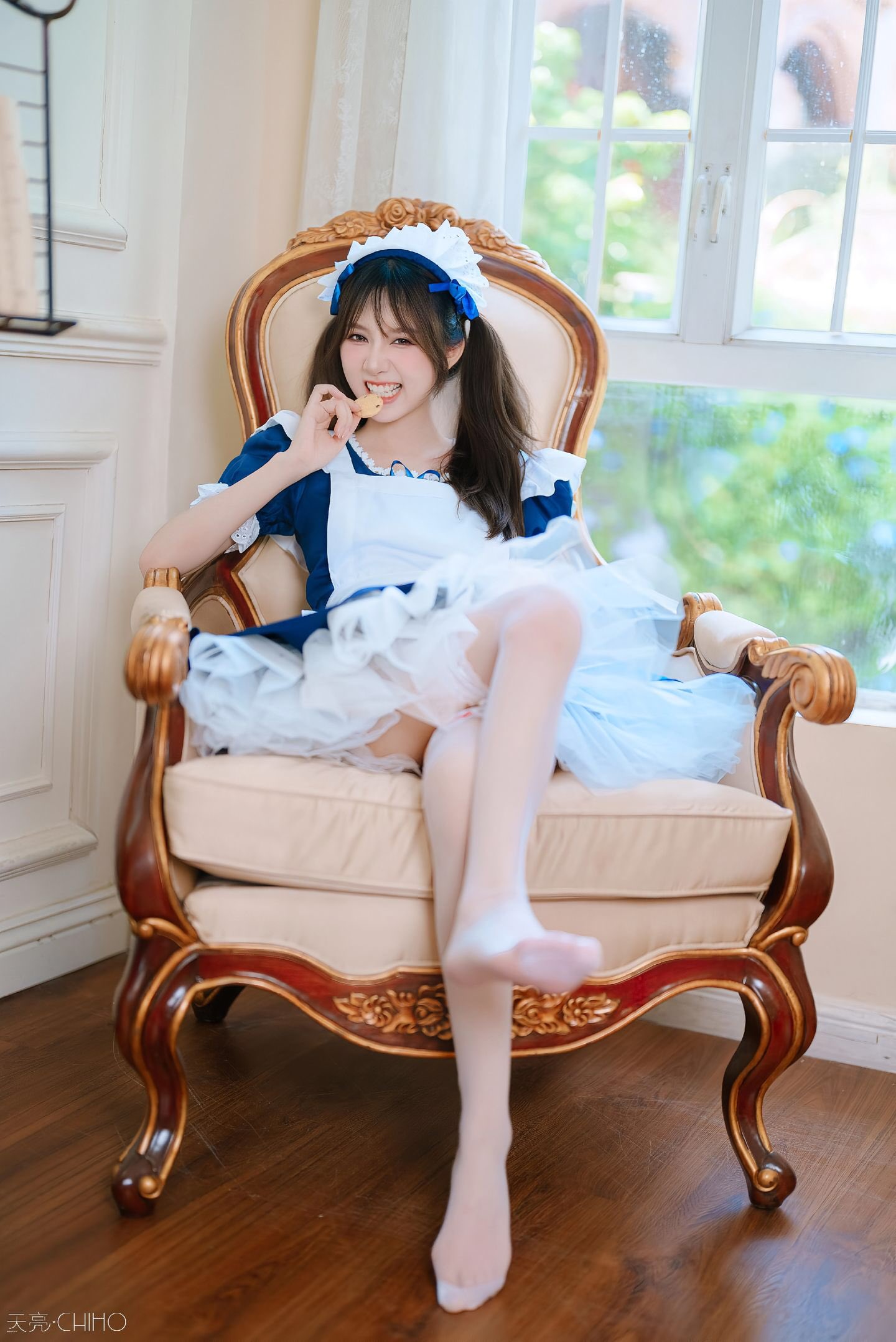 穿着蓝色衣服的女孩坐在椅子上。