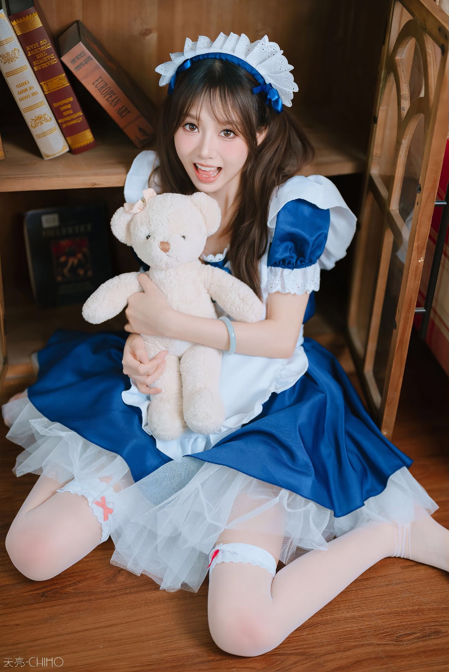 穿着蓝色衣服的女孩坐在椅子上。