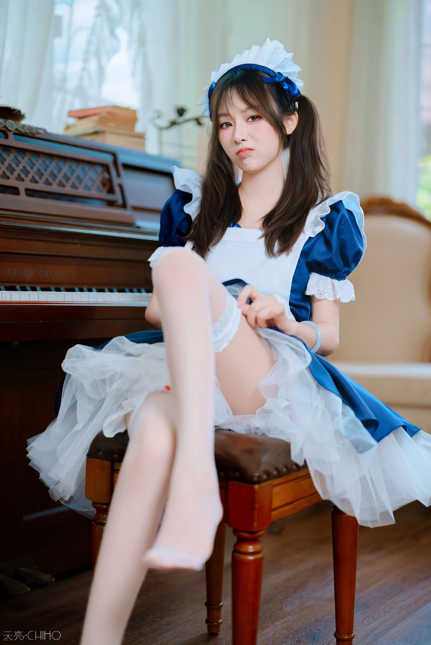 穿着蓝色衣服的女孩坐在椅子上。