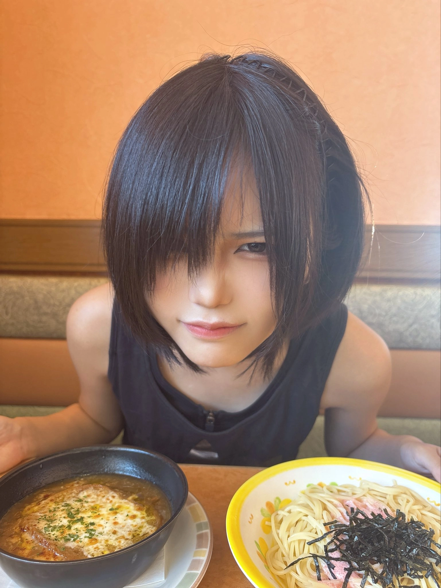 黑头发和黑色坦克顶的女孩正在看着相机。