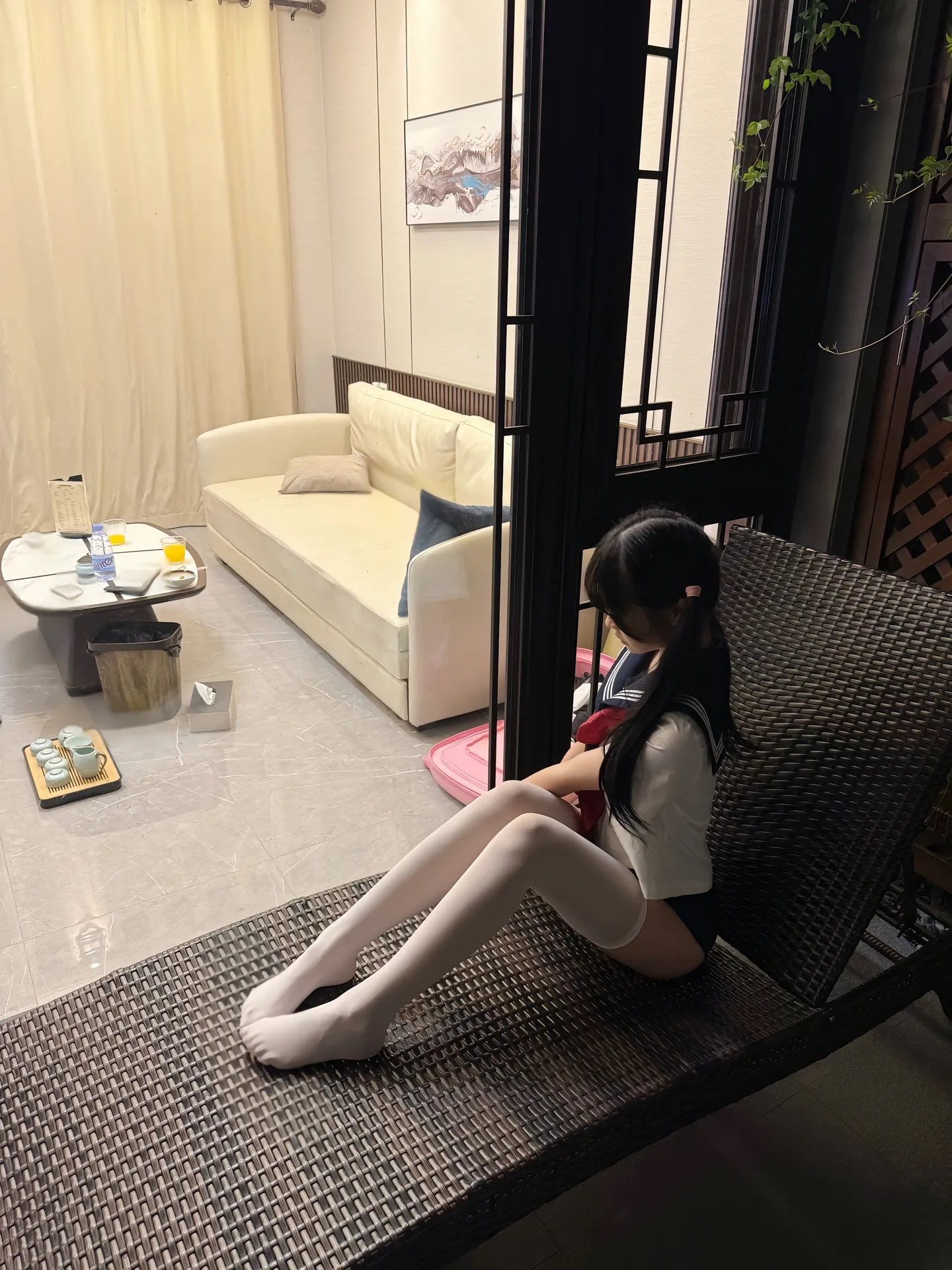 穿着水手服的女孩坐在一个椅上。