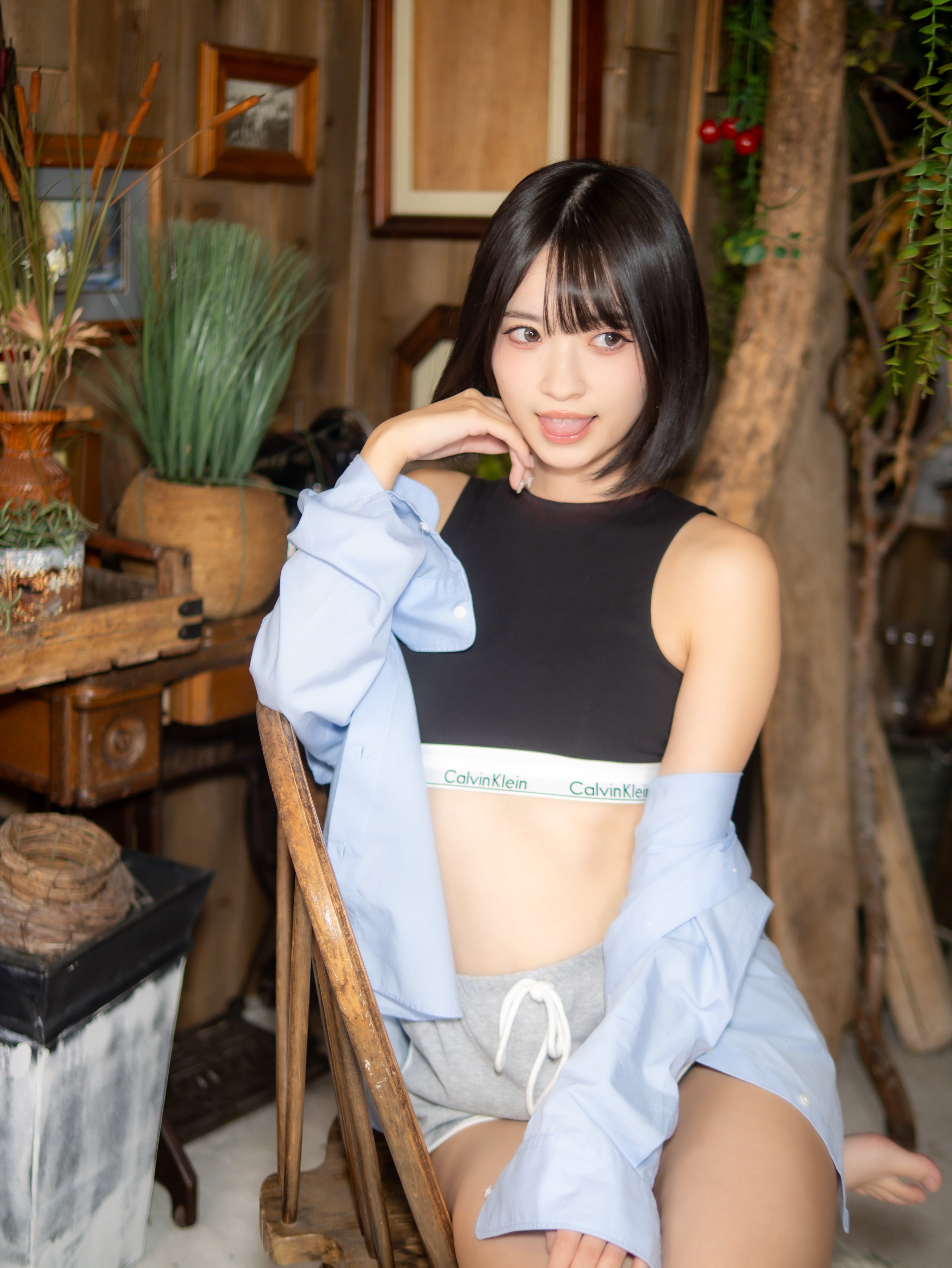 穿着黑色顶部和白色胸罩的女人坐在椅子上。