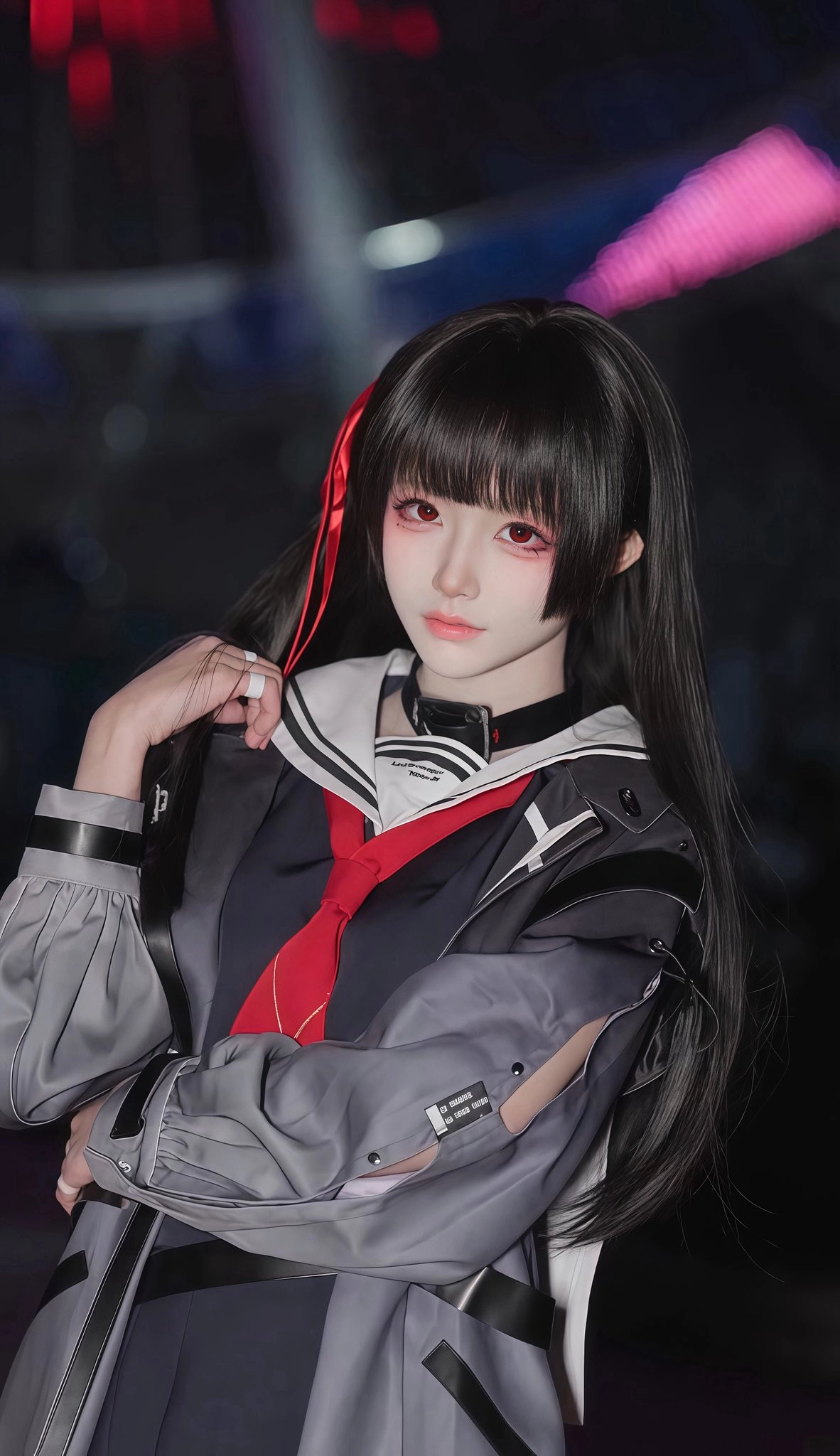 黑头发和红嘴唇的女人穿着一件黑色和红色的夹克。