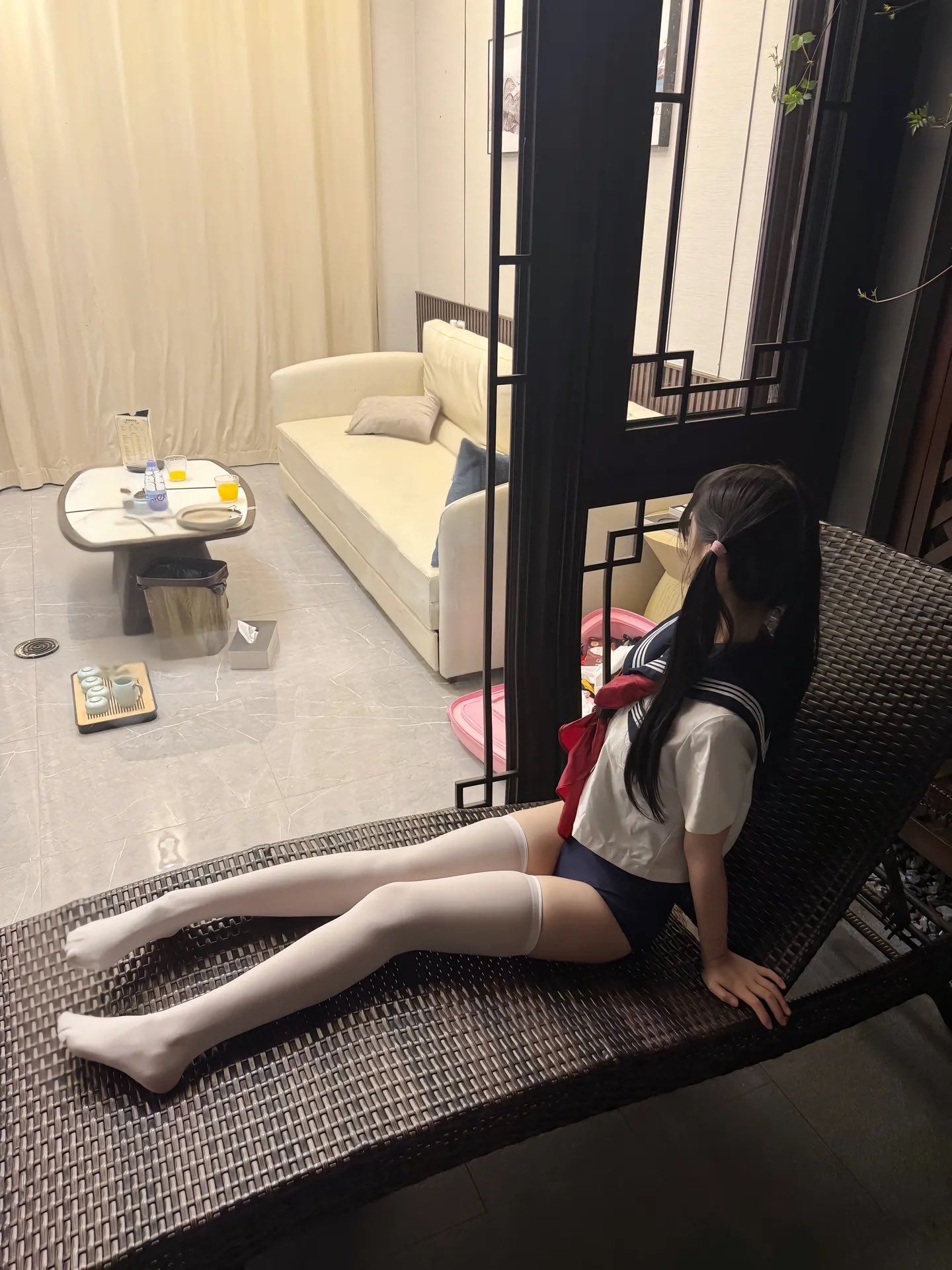 穿着水手服的女孩坐在一个椅上。