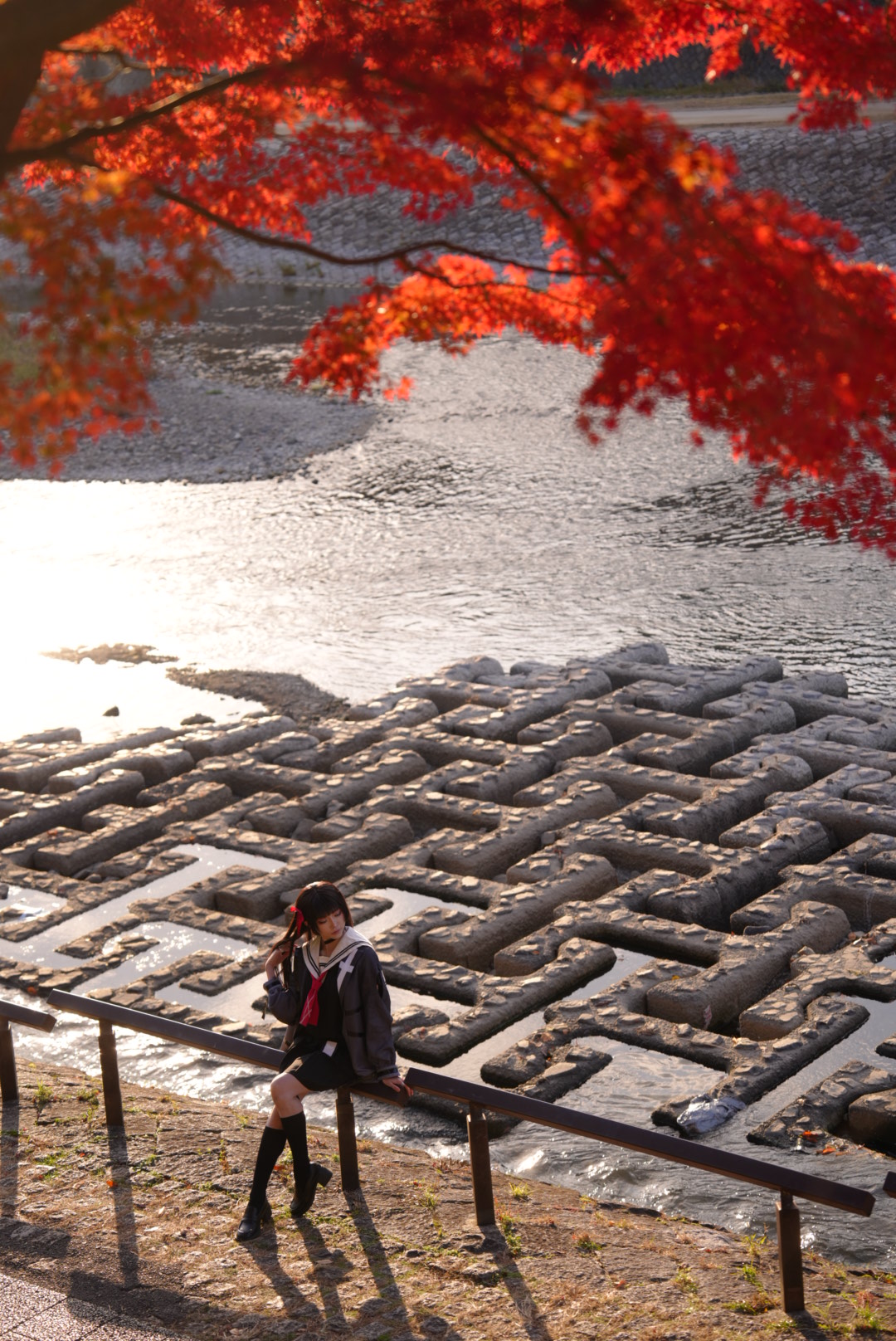 女人站在一座桥上,望着一条河。