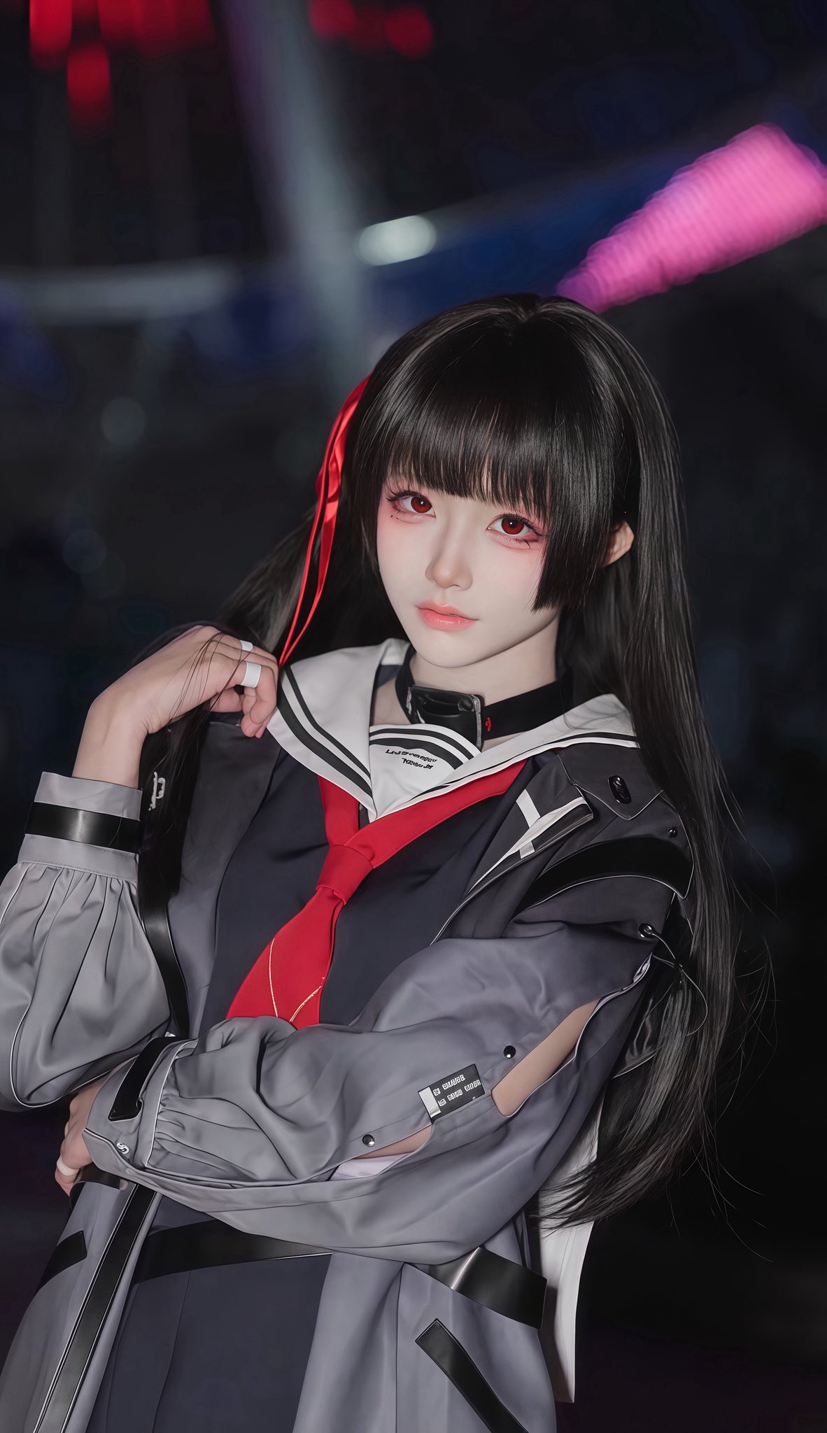 黑头发和红嘴唇的女人穿着一件黑色和红色的夹克。