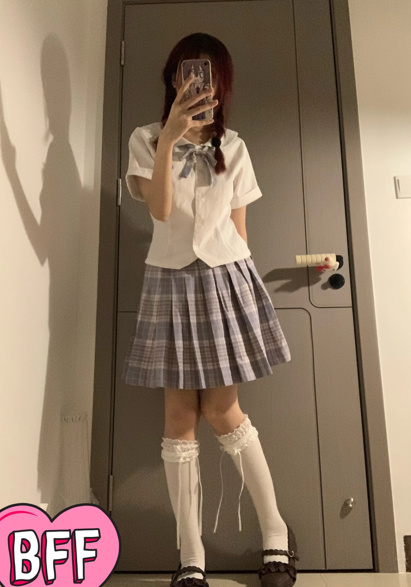 穿着白色衬衫和蓝色裙子的女孩拍了一张自拍。