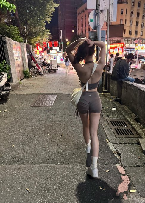 带着白袋子的女人走在街上。