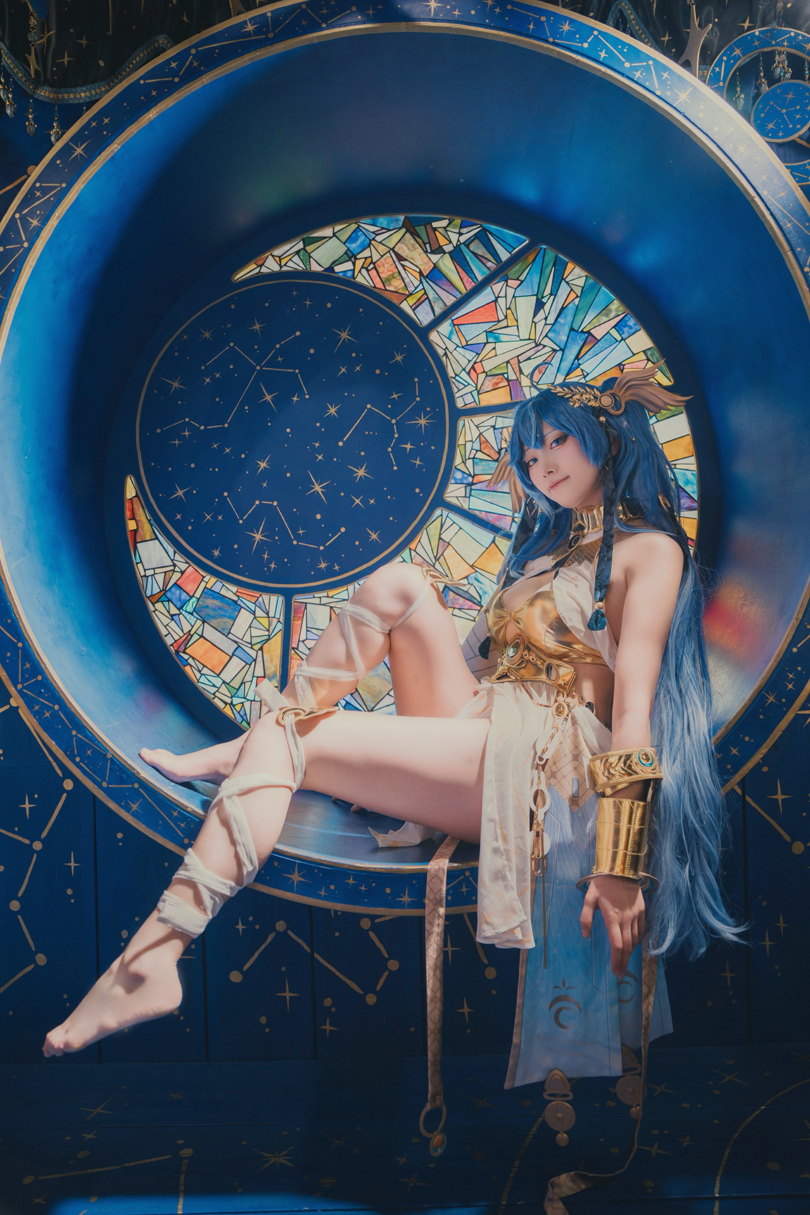 穿着金色和蓝色服装的女人坐在椅子上。