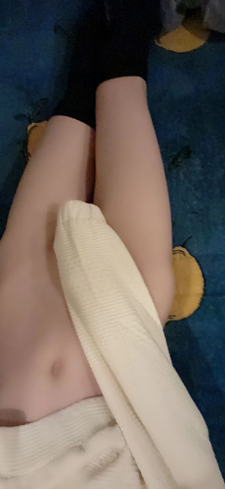 女人躺在毯子上,一个毛巾包围在她周围。