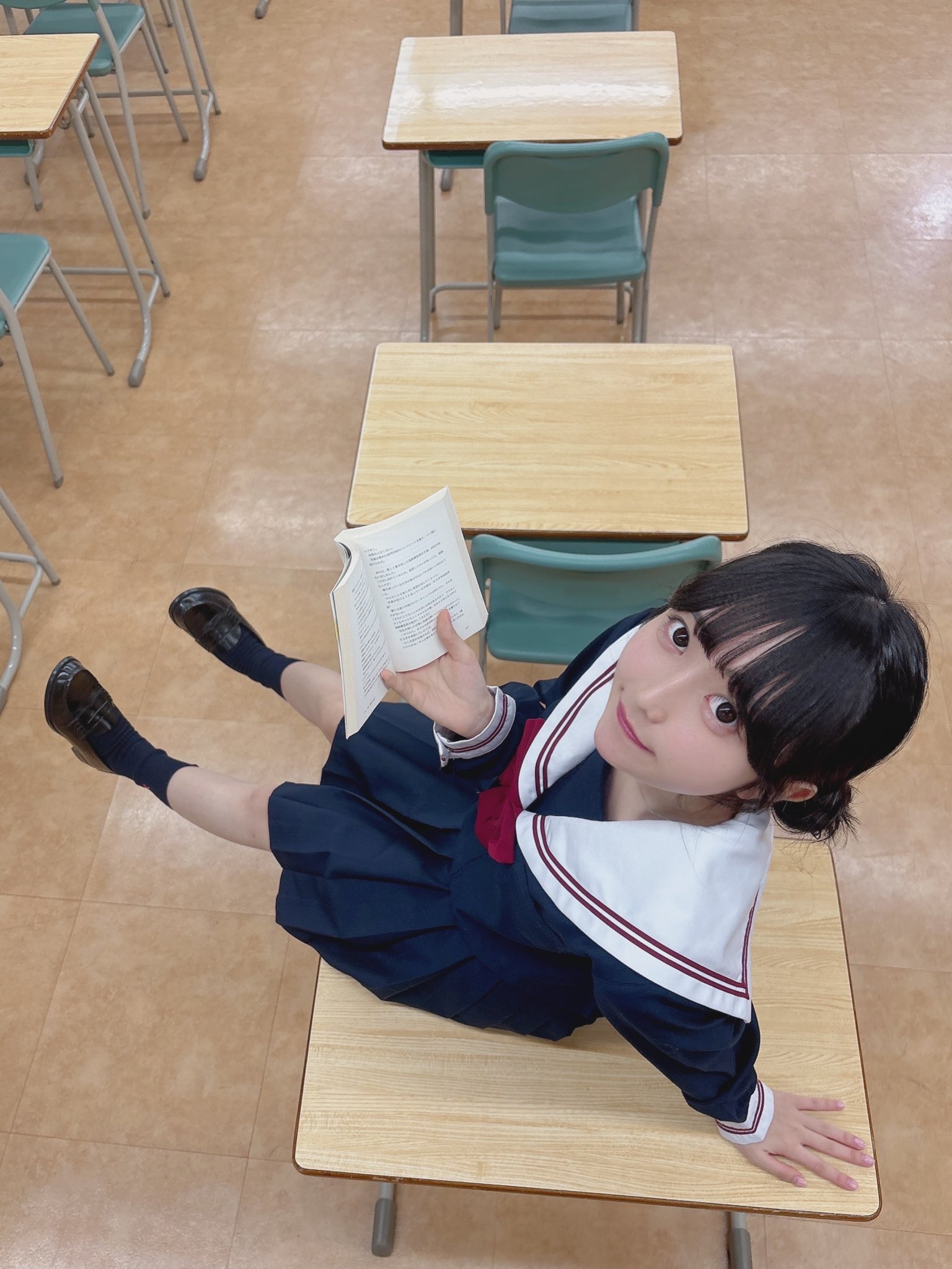 女孩在坐在桌子上读一本书。