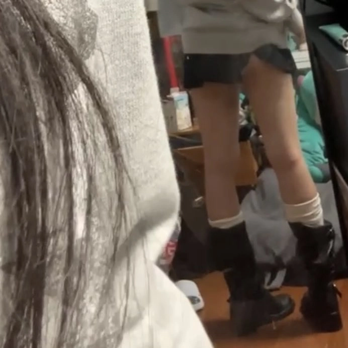 穿着灰色衬衫和黑色靴子的女人。