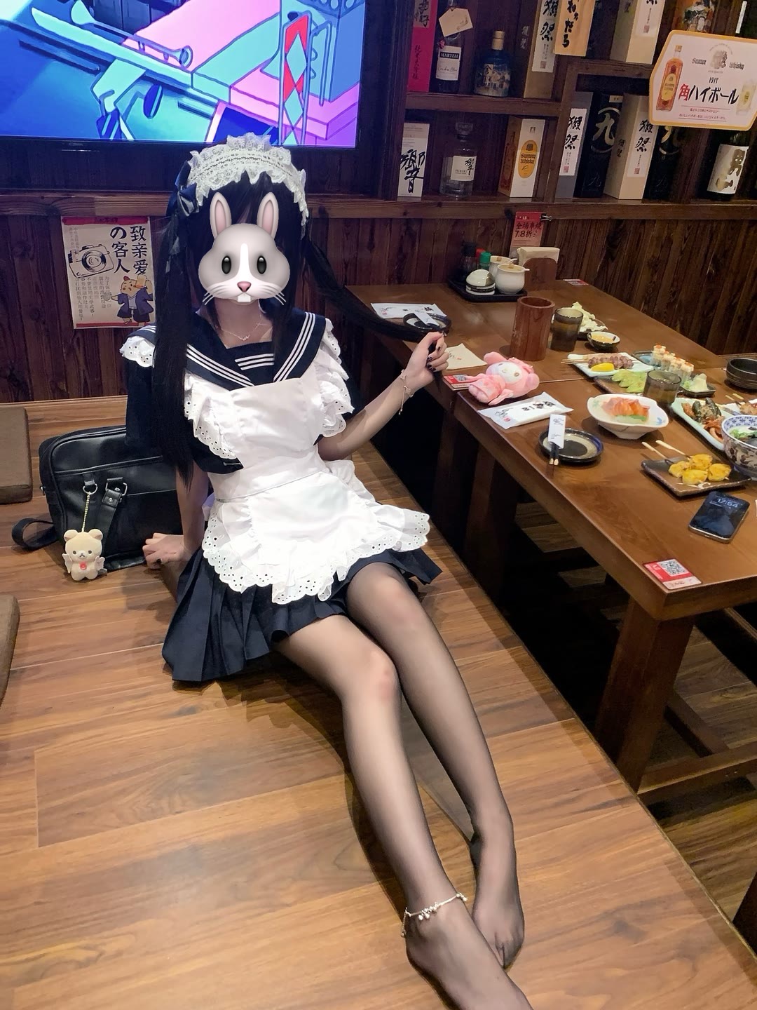 穿着女仆的衣服的女人坐在一张桌子上。