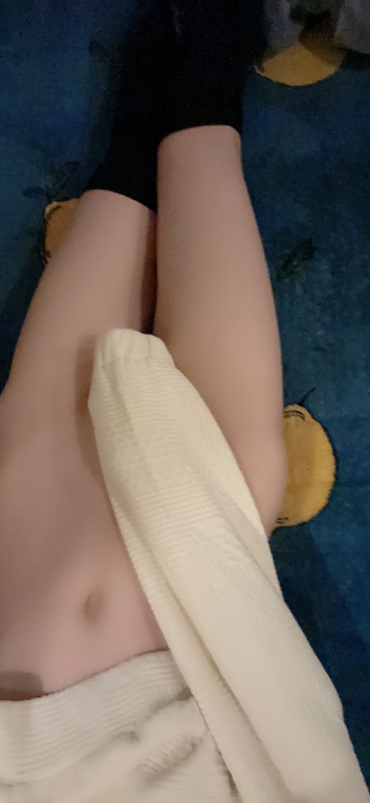 女人躺在毯子上,一个毛巾包围在她周围。