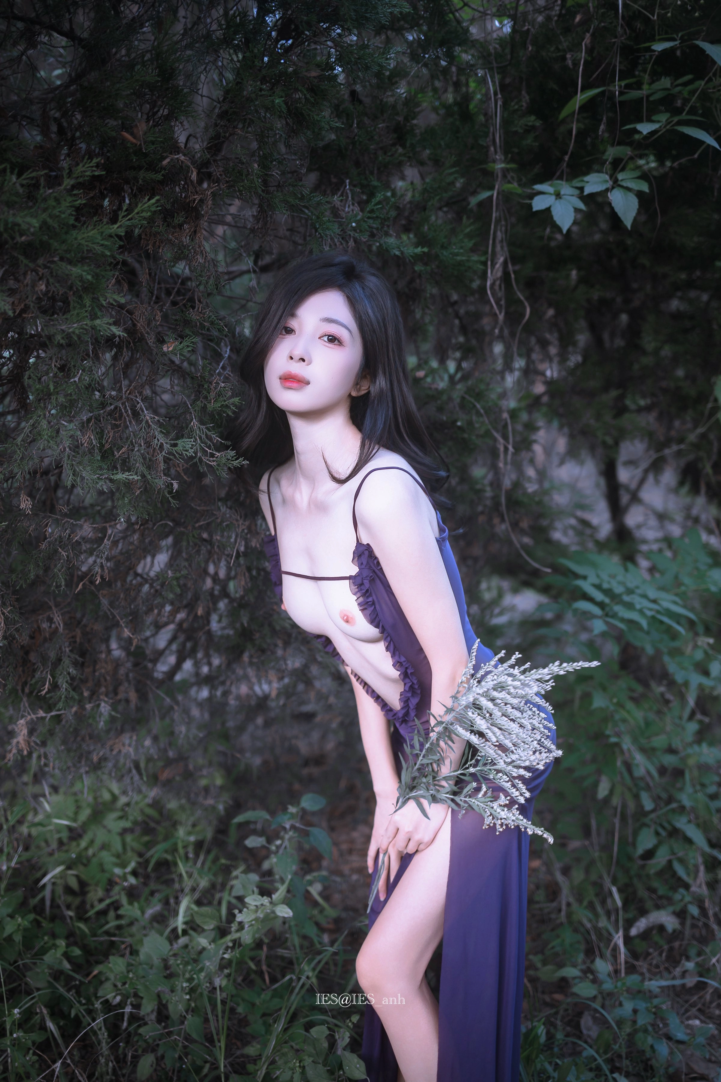 A woman in purple clothes stood in the woods.