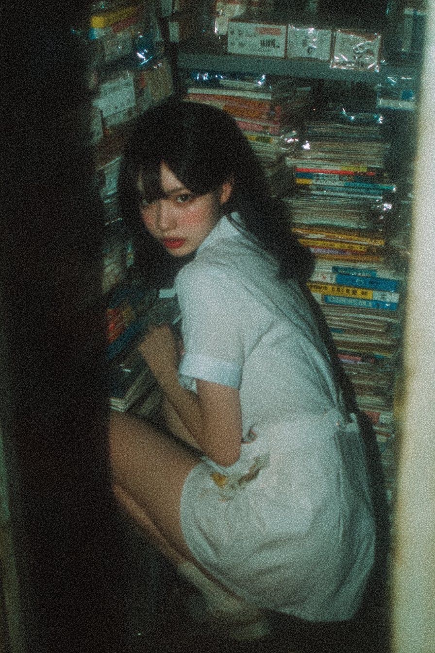 穿白色衣服的女人坐在书架上。