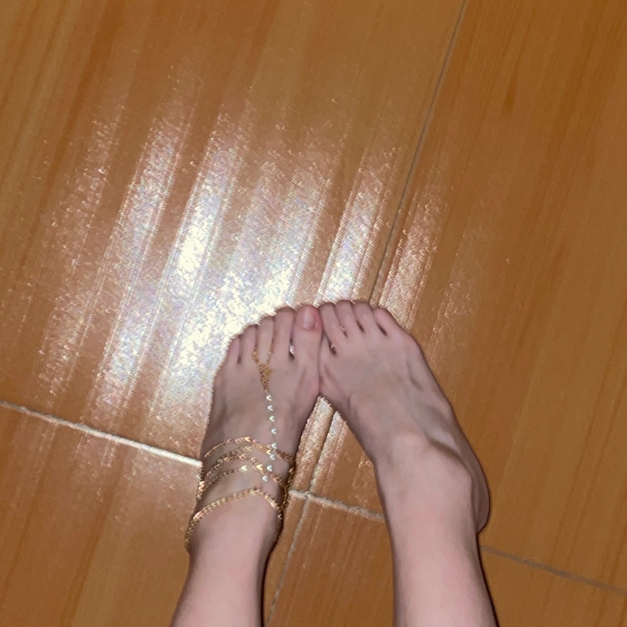 女人的裸足在木地板上。