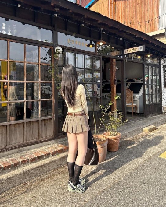 长头发和一件黑色夹克的女人走在街上。