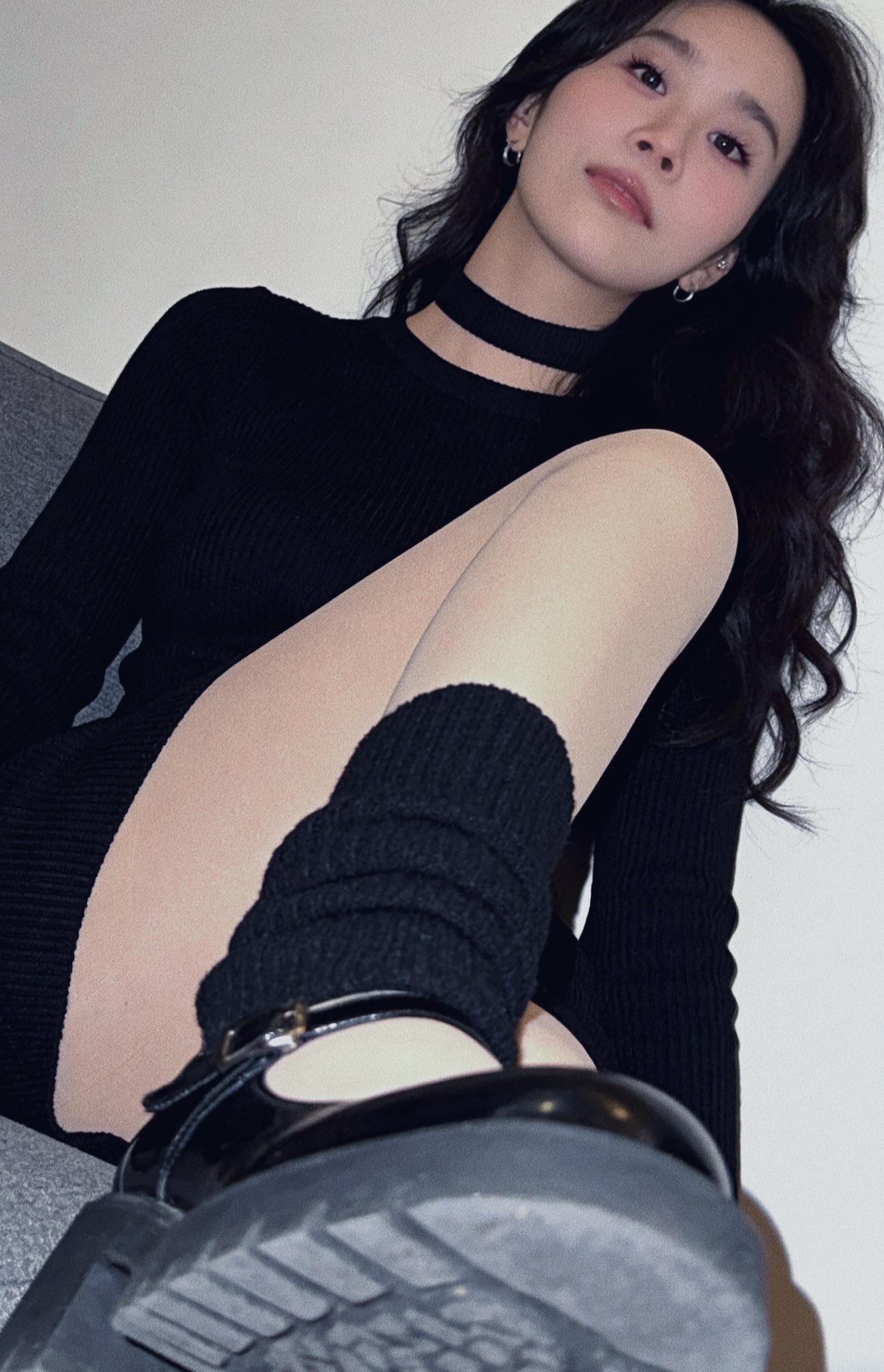 穿着黑色衬衫和黑色衬衫的女人坐在沙发上。